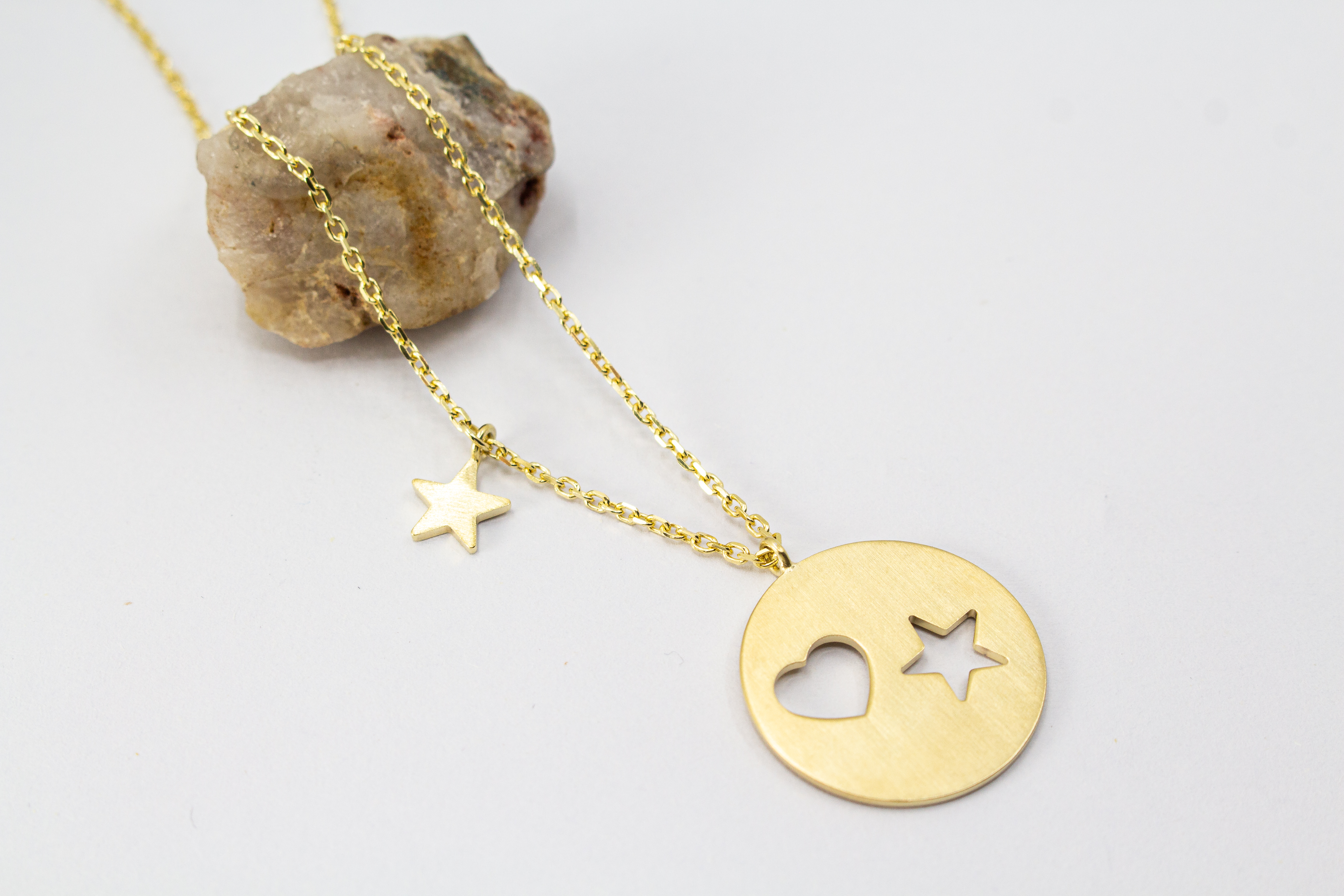 Collier „Sternenliebe“ aus vergoldetem 925er Sterlingsilber mit rundem Anhänger, Herz- und Sternmotiv sowie zusätzlichem Sternanhänger.