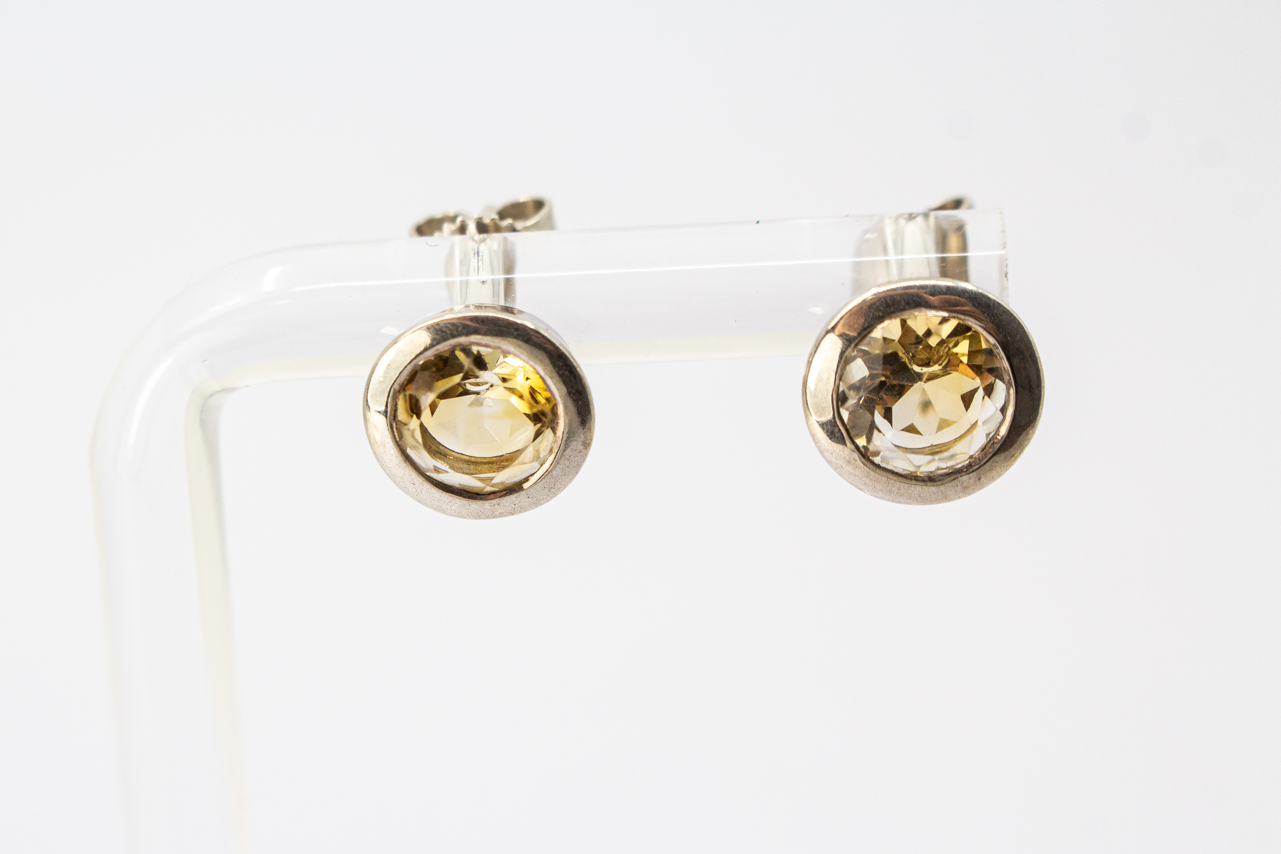 klassische, runde Ohrstecker aus glänzendem 925 Sterling Silber mit einem facettierten, hellgelben Citrin-Edelstein in einer glatten Zargenfassung aus dem Online-Shop der Goldschmiede Regina Kraus.