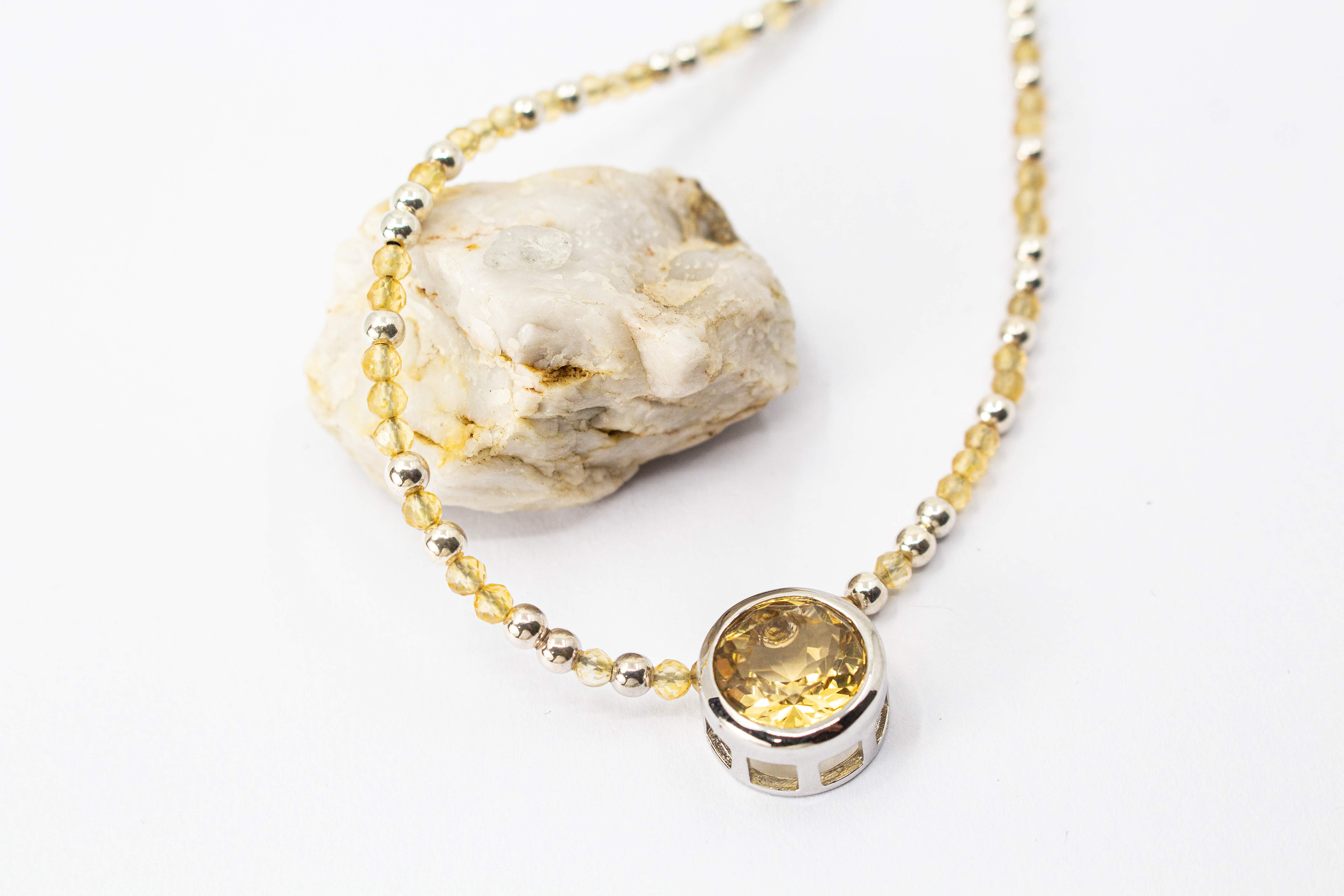 Elegantes Edelsteincollier aus kleinen, facettierten, hellgelben Citrin-Perlen im Wechsel mit glänzenden 925 Silberkügelchen und einem großen, runden Citrin-Edelstein als Anhänger in einer silbernen Fassung aus dem Online-Shop der Goldschmiede Regina Krau