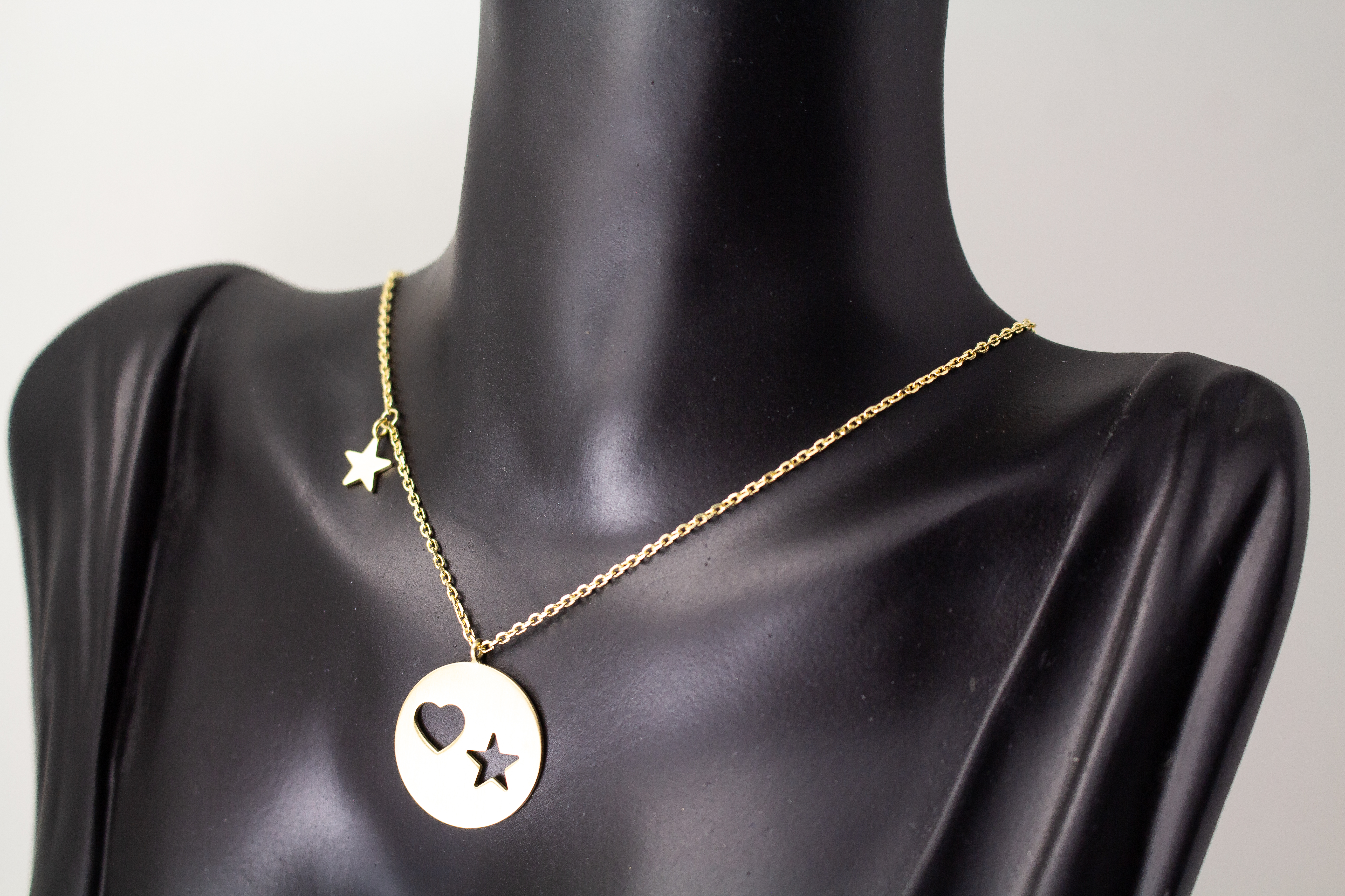Collier „Sternenliebe“ aus vergoldetem 925er Sterlingsilber mit rundem Anhänger, Herz- und Sternmotiv sowie zusätzlichem Sternanhänger.