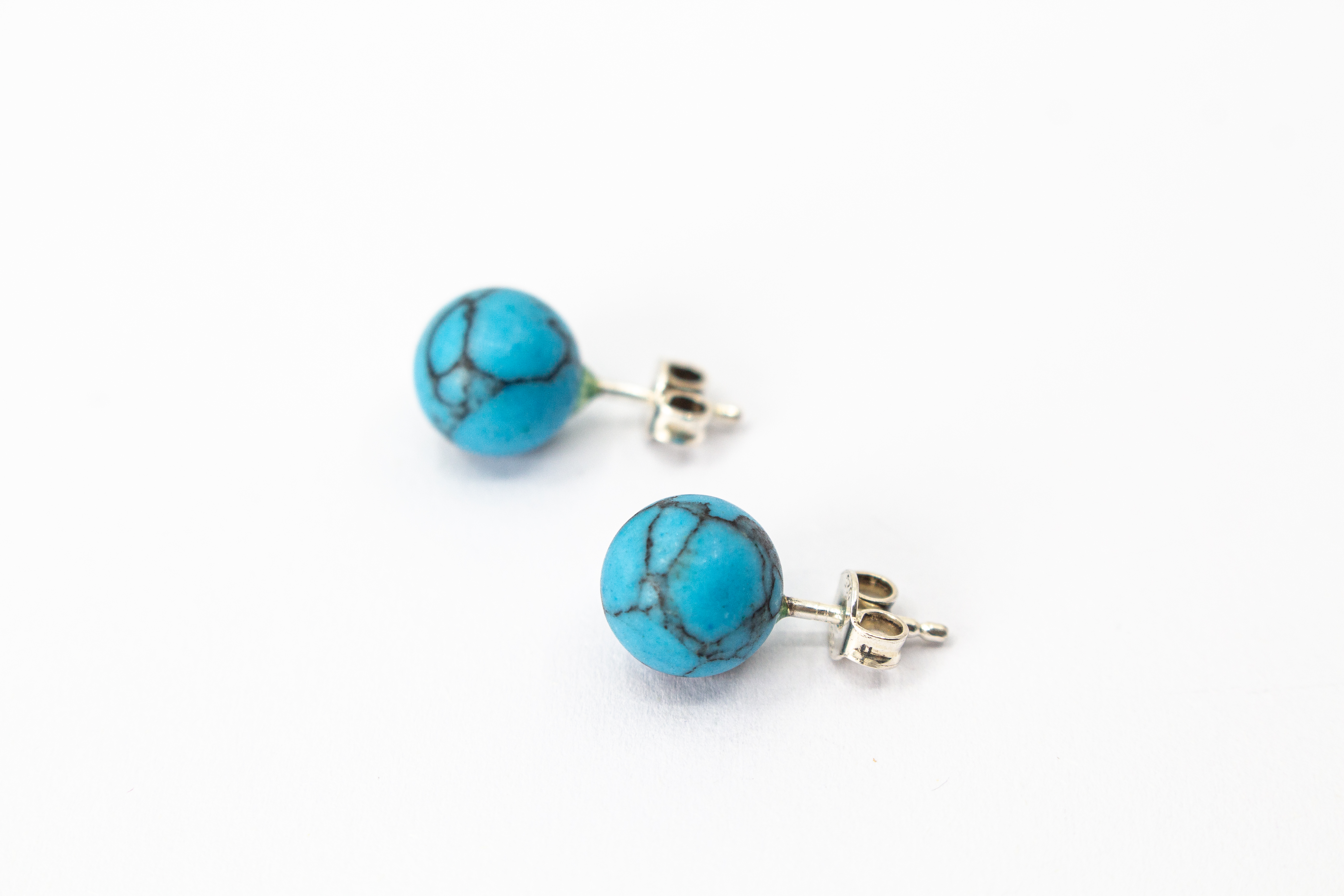 Klassische Kugelohrstecker aus leuchtend blauem Türkis-Edelstein mit charakteristischer dunkler Aderung und Stiften aus 925 Sterling Silber aus dem Online-Shop der Goldschmiede Regina Kraus.