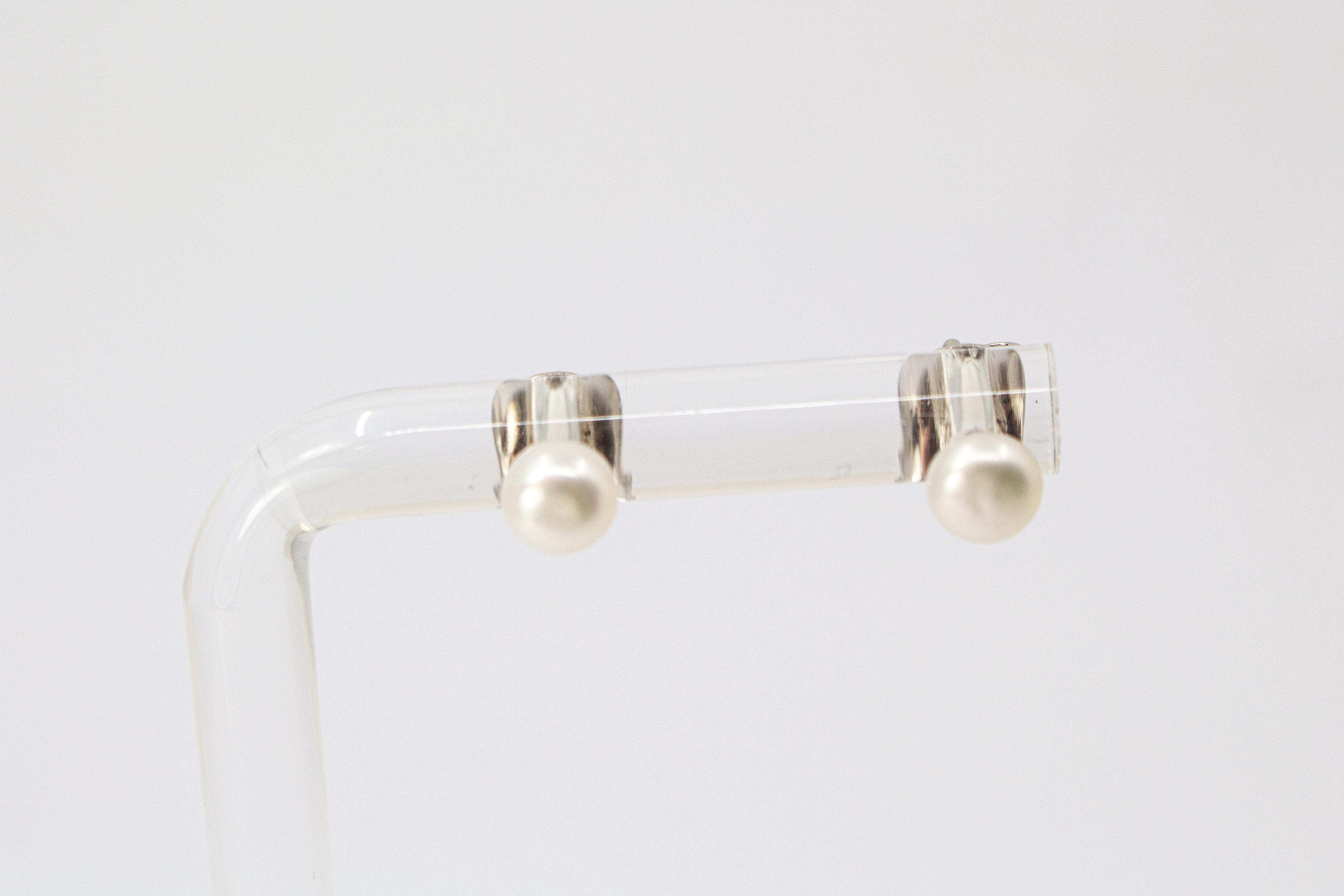 Ein Paar klassische Perlenohrstecker aus 925er Sterlingsilber mit je einer runden, weiß schimmernden Süßwasserzuchtperle