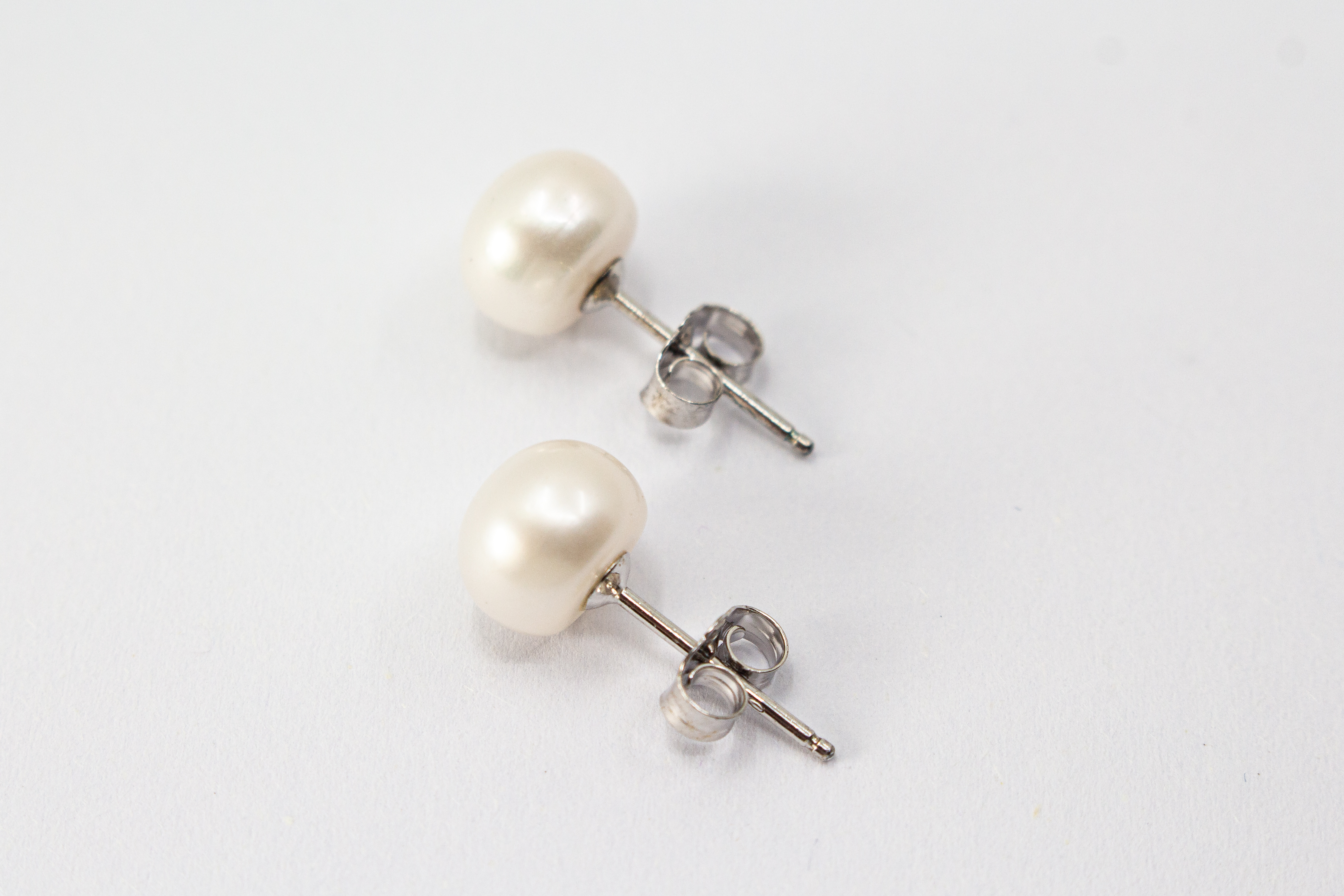Elegante Ohrstecker „Mondperle“ aus 925er Sterlingsilber mit schimmernden weißen Süßwasserzuchtperlen im zeitlosen Design.