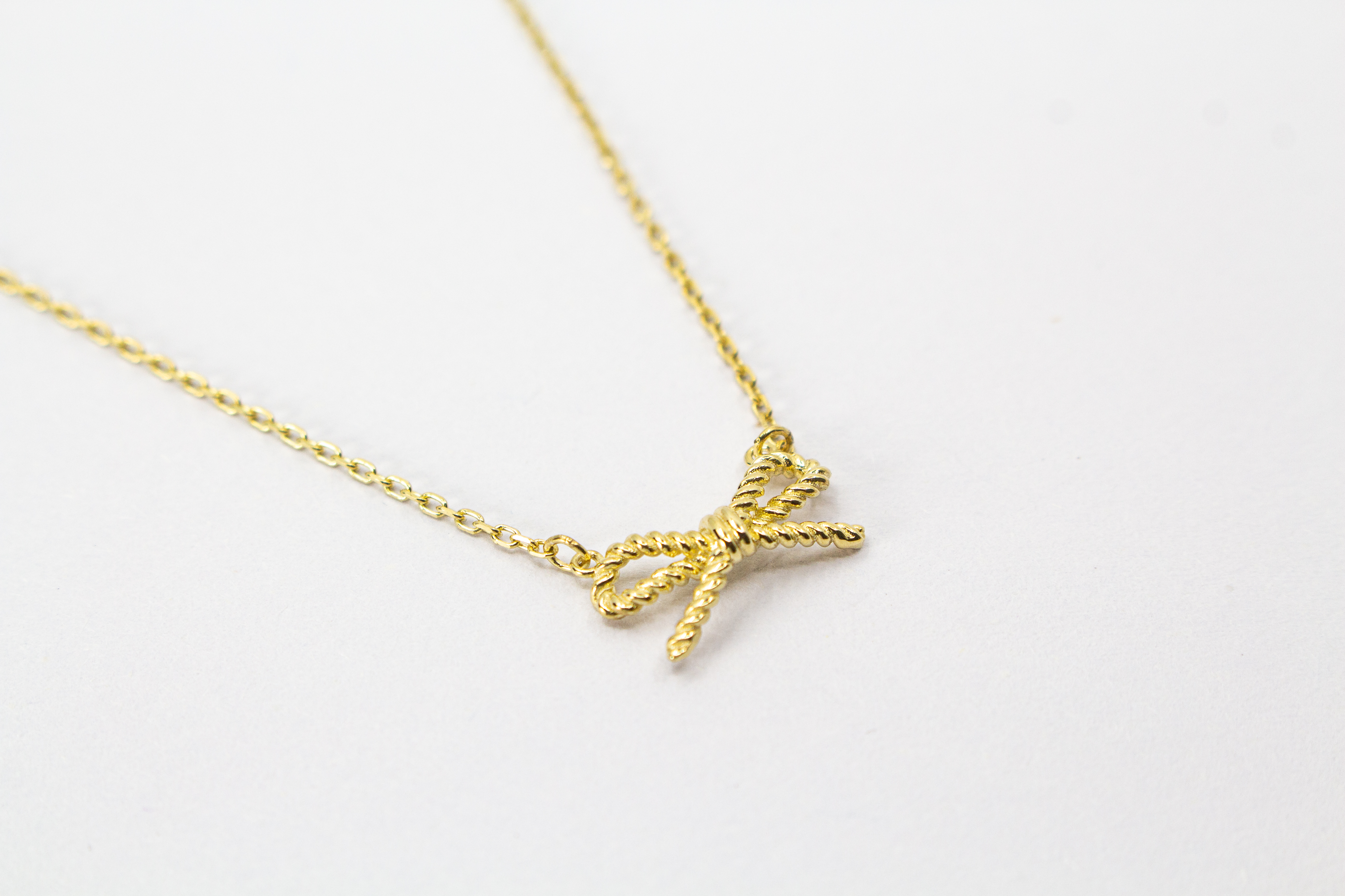 Collier „Schleifenzauber“ aus vergoldetem 925er Sterlingsilber mit filigranem Schleifenanhänger in elegantem, zeitlosem Design.