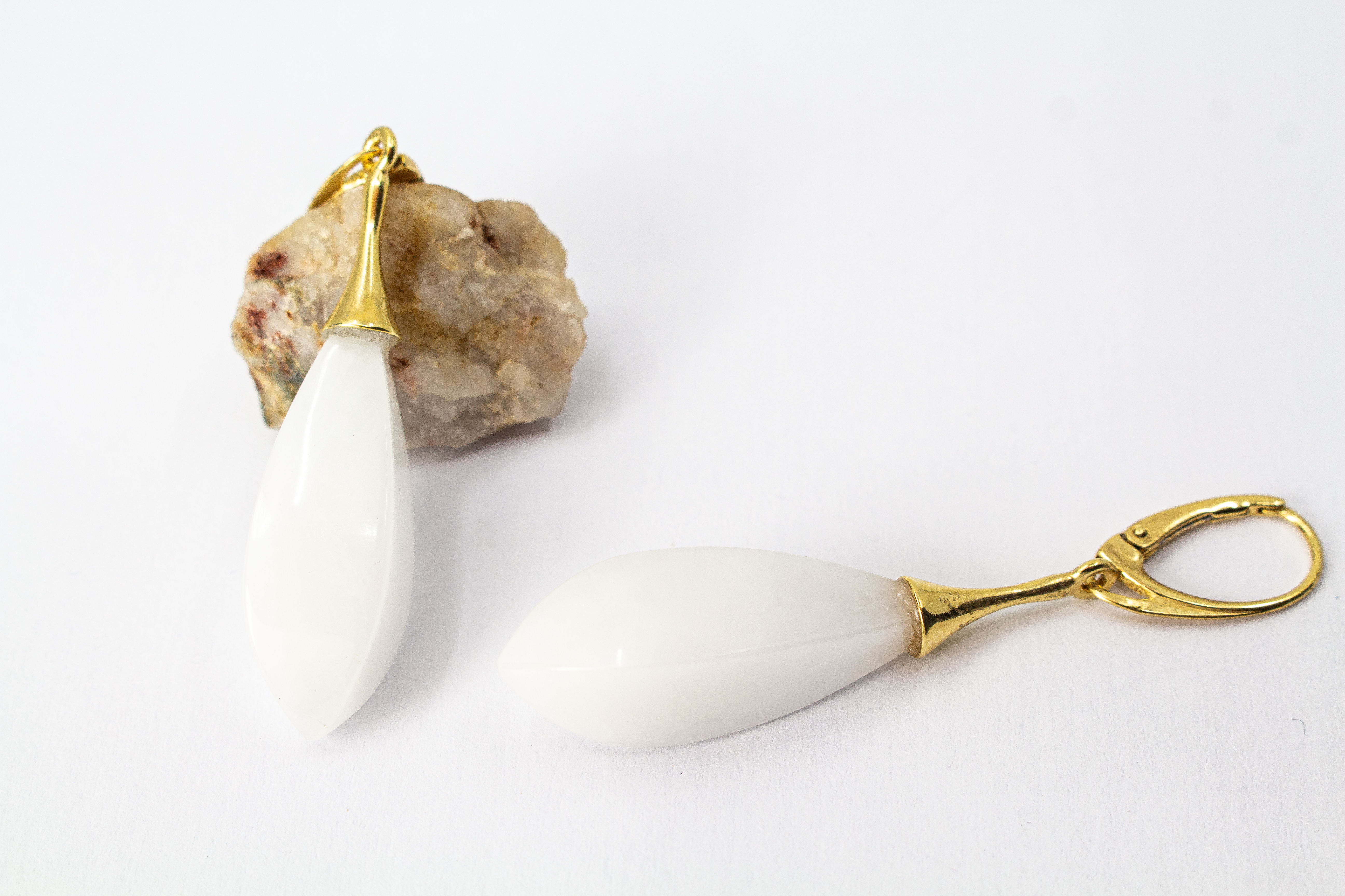 Elegante Tropfen-Ohrhänger mit weißem, porzellanartigen Kascholong-Edelstein und einer vergoldeten Brisur aus 925er Sterlingsilber von der Goldschmiede Regina Kraus.