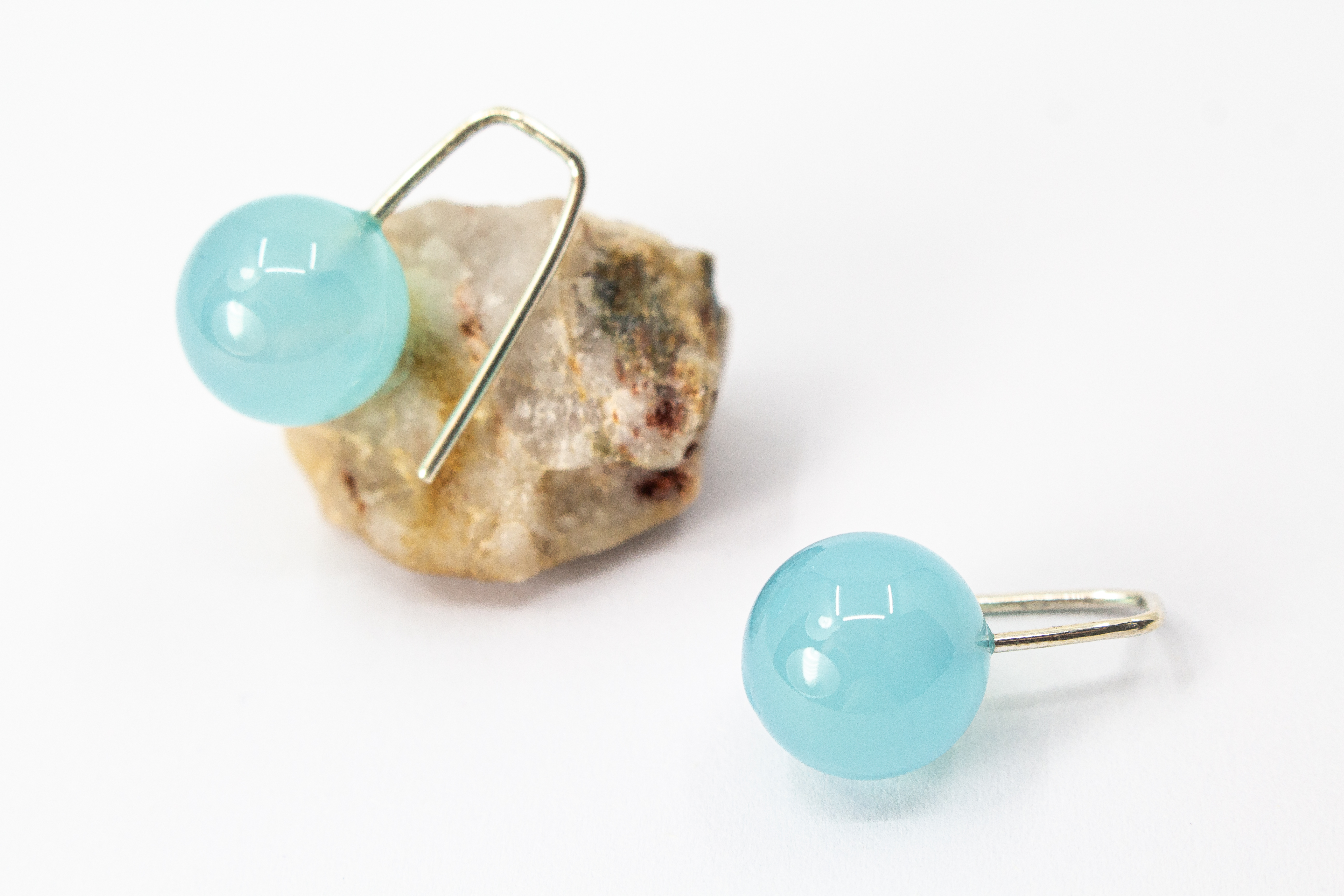 Minimalistische Ohrhänger aus feinen 925 Sterling Silberbügeln mit je einer glatten, hellblauen Chalcedon-Edelsteinkugel aus dem Online-Shop der Goldschmiede Regina Kraus
