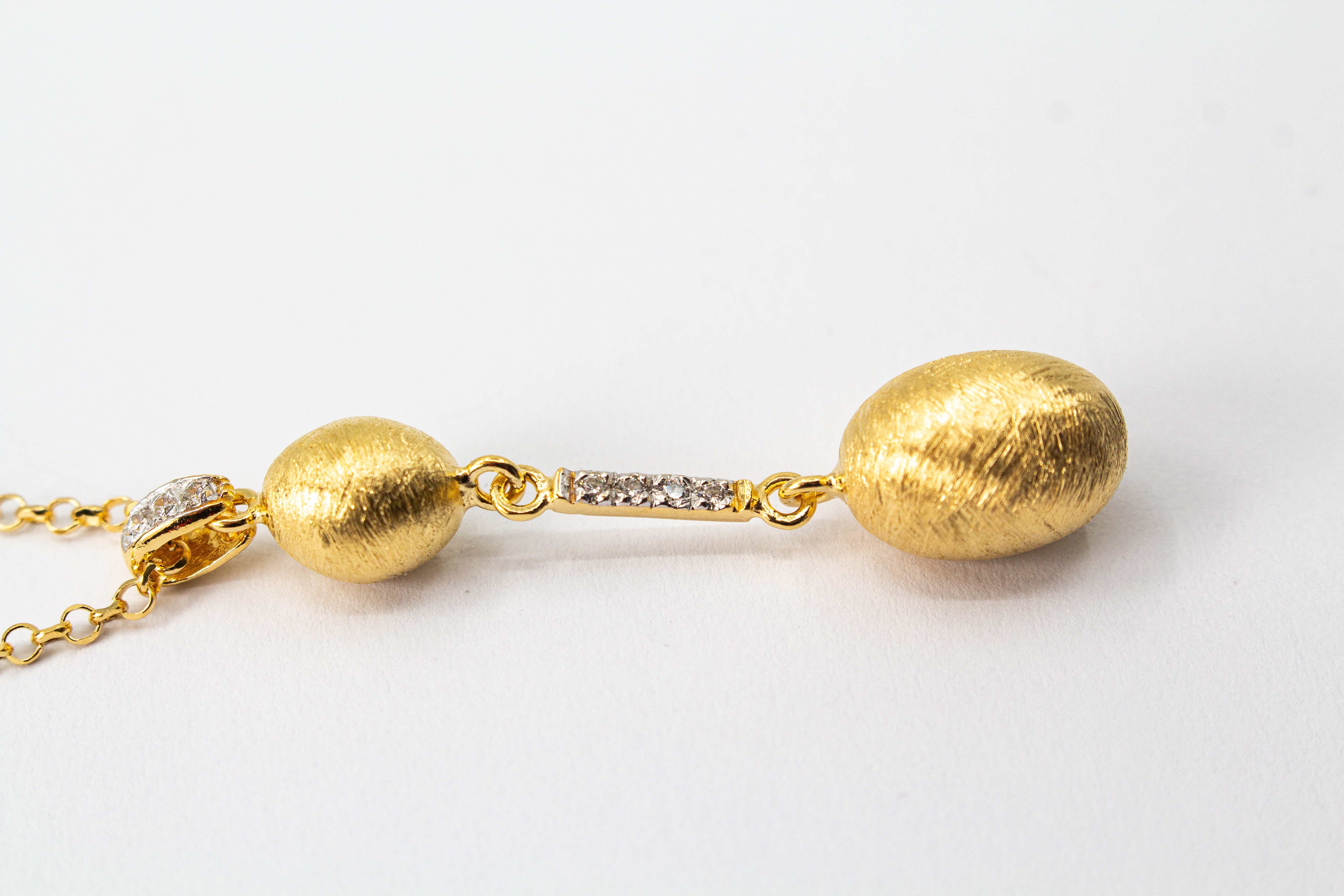 Elegante Halskette von Diva Gioielli aus vergoldetem 925 Silber mit zwei mattierten, ovalen Schmuckelementen, die durch einen mit funkelnden Zirkonia besetzten Steg verbunden sind.