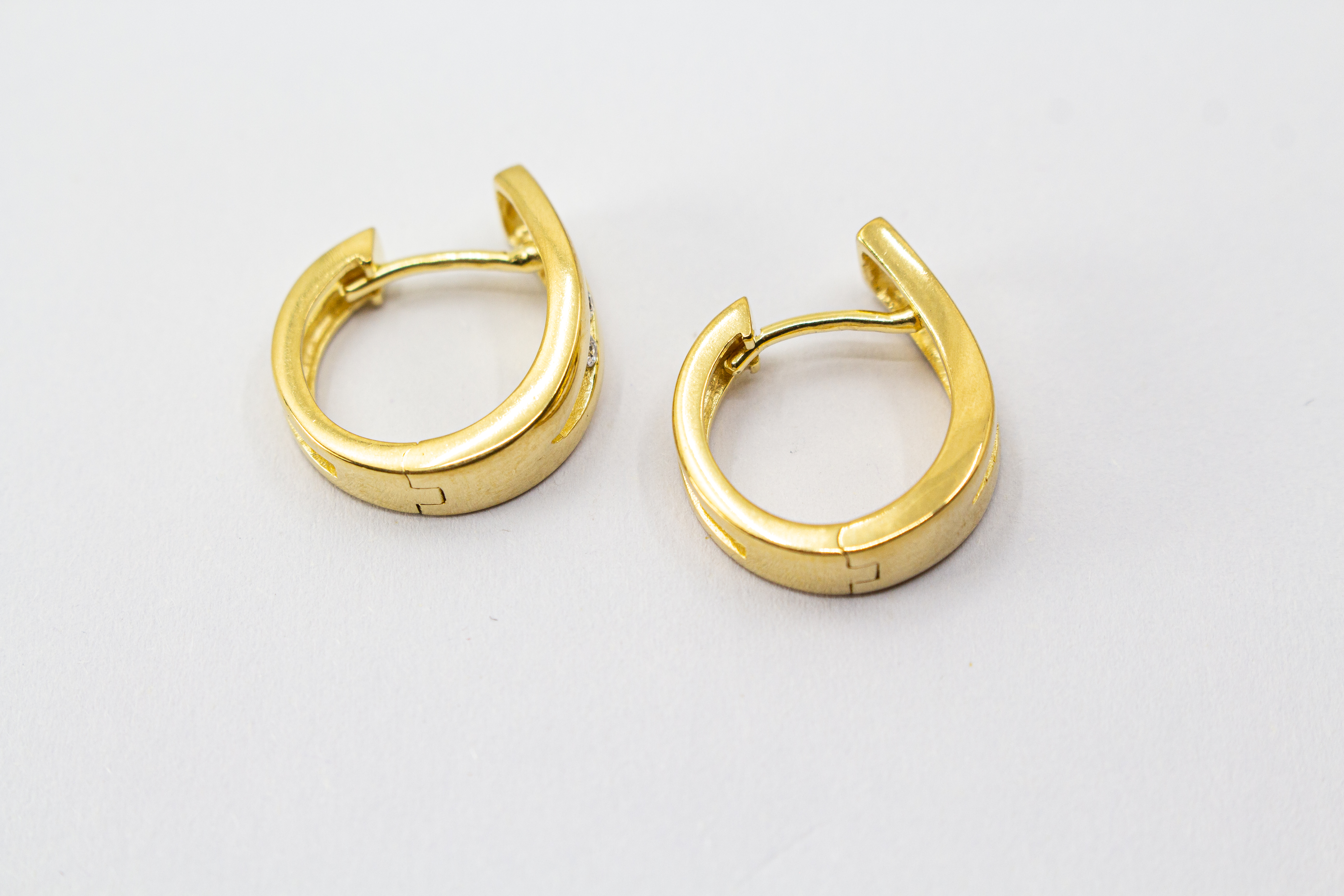 Elegante Creolen „Goldfunken“ aus 20 Mikron vergoldetem 925er Sterlingsilber mit funkelnden Zirkonia in geschwungener Form.