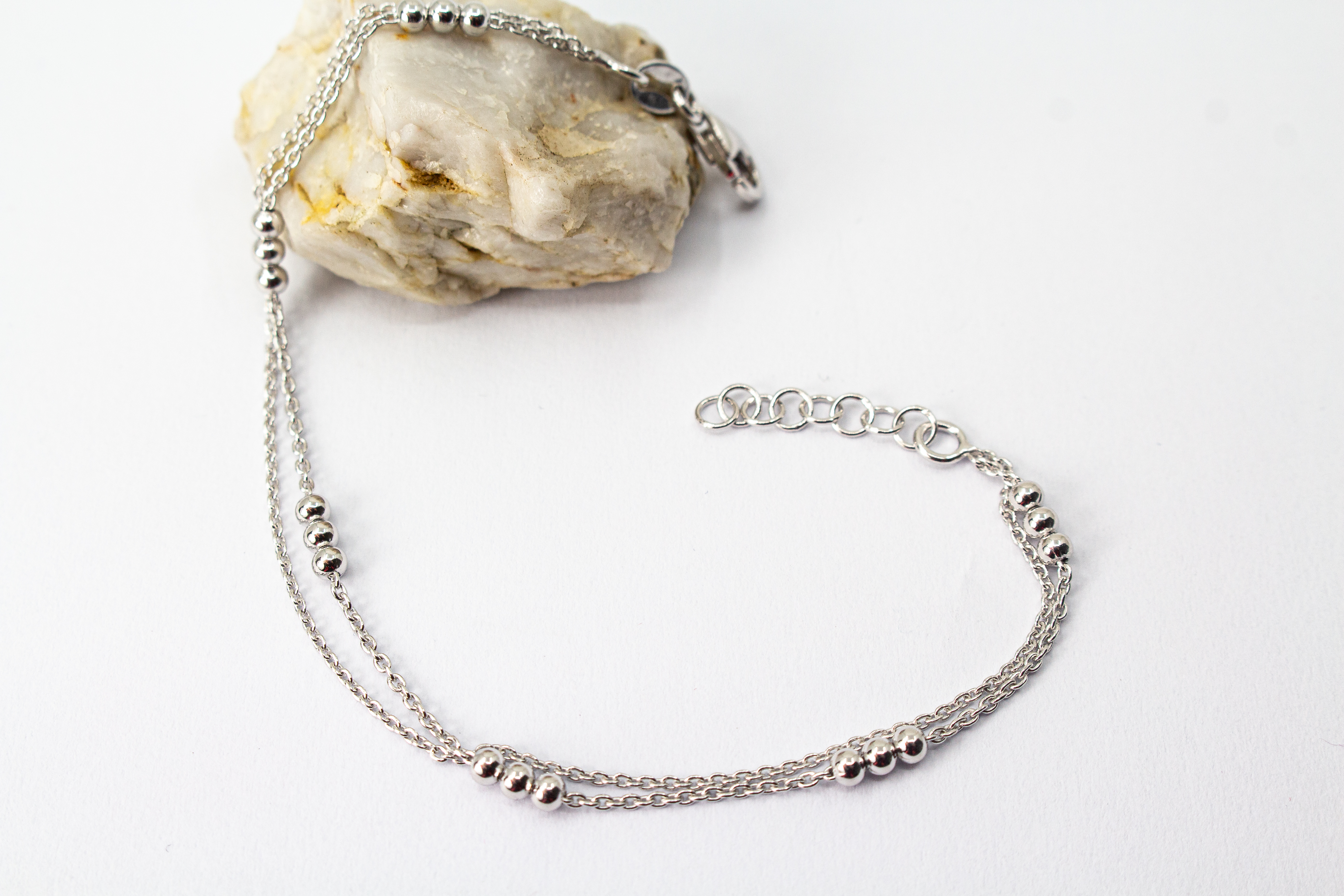 Zweireihiges Armband der Goldschmiede Regina Kraus aus hochwertigem rhodiniertem 925er Silber mit kleinen Silberkugeln in Dreiergruppen auf feinen Ankerketten.