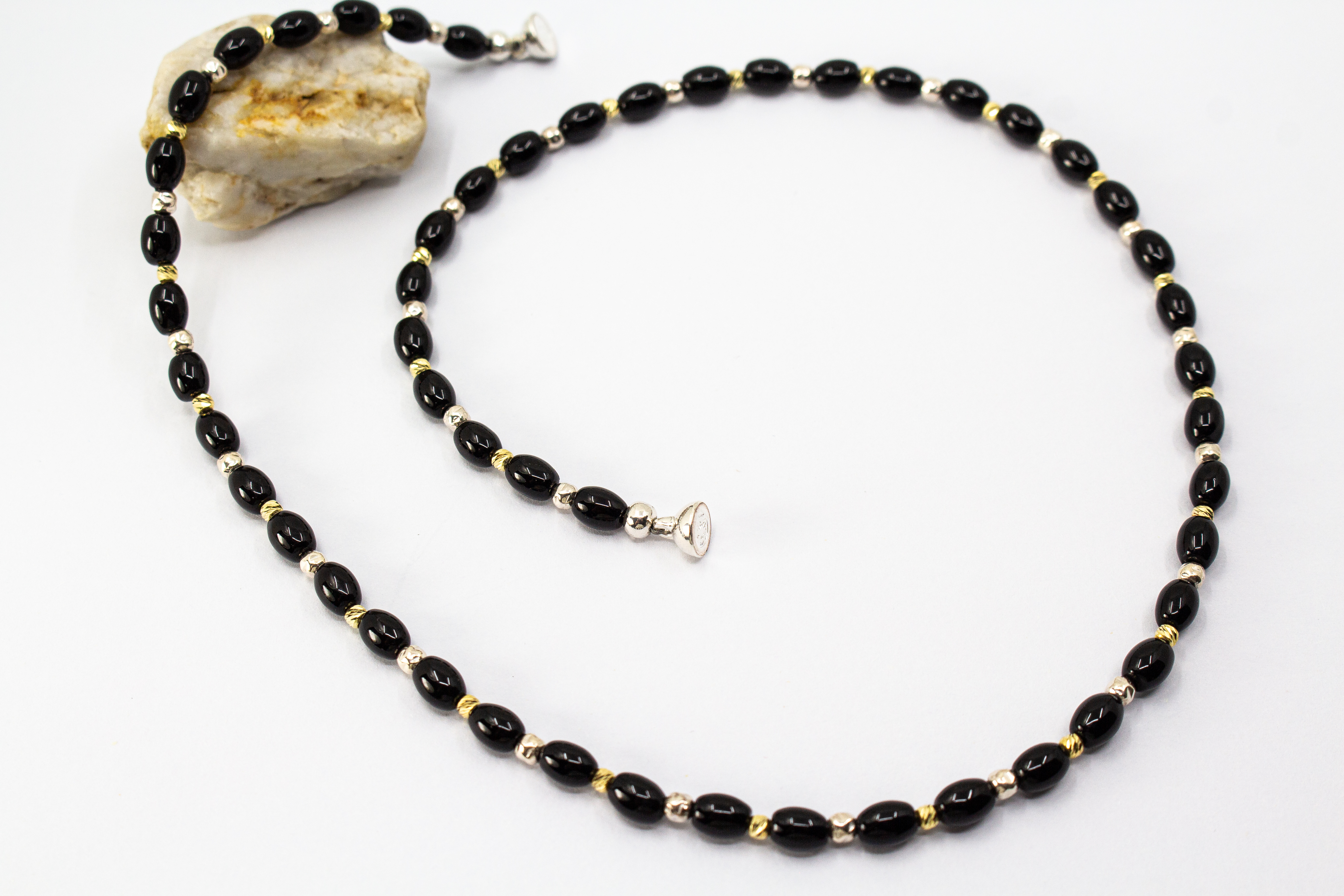 Elegante Onyx Kette „Mitternachtsglanz“ mit schwarzen Onyx-Perlen, Zwischenteilen aus 925er Sterlingsilber und vergoldeten Silberdetails.