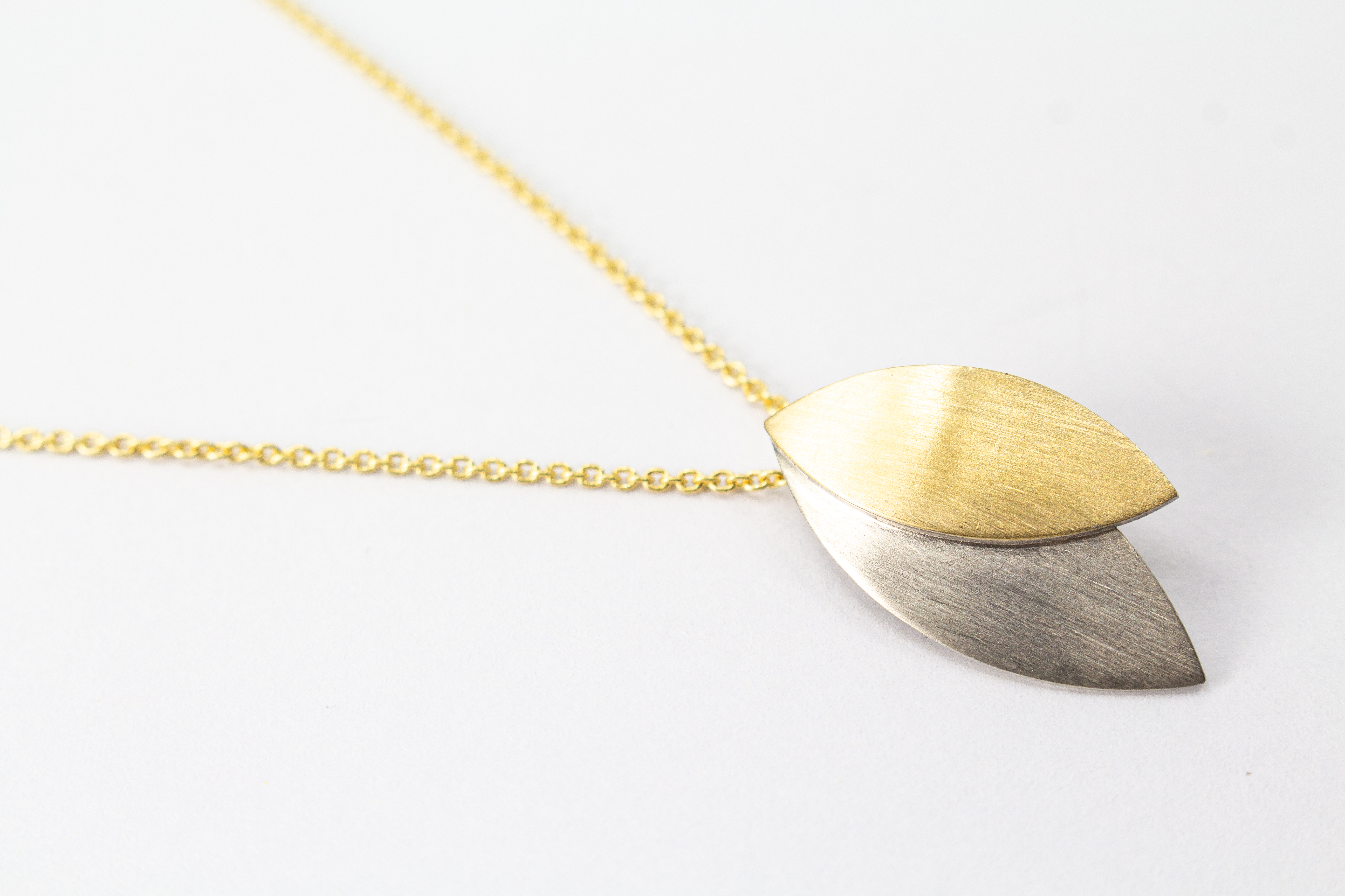 Kette „Blattgold“ aus 925er Sterlingsilber mit Feingoldbelötung und zweifarbigem Anhänger in filigraner Blattform.