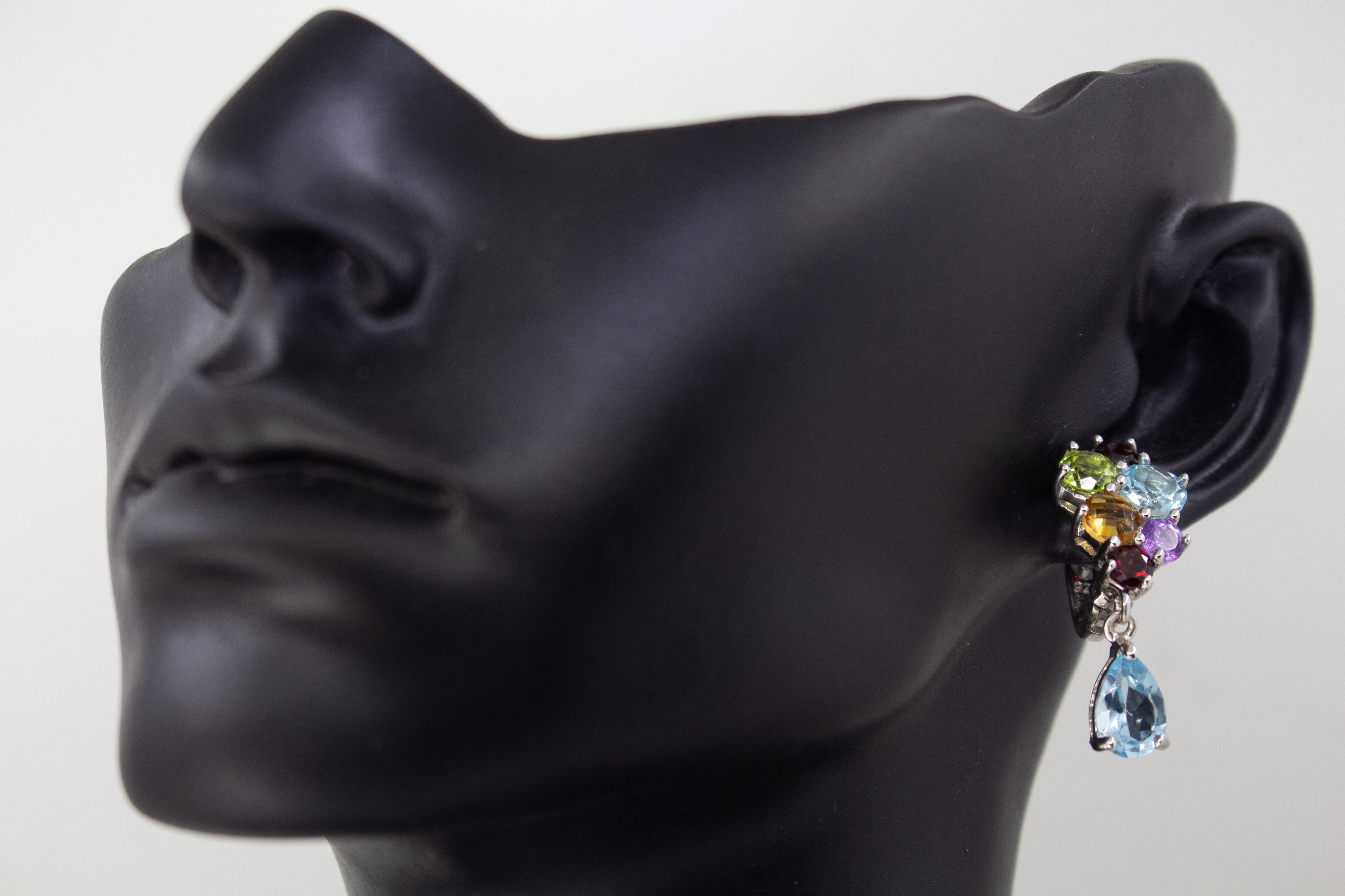Elegante Multicolor-Edelstein-Ohrhänger aus rhodiniertem 925 Silber von der Goldschmiede Regina Kraus. Die detailreichen Ohrringe zeigen ein farbenfrohes Cluster aus rund facettierten Steinen wie Amethyst, Peridot, Citrin und Granat, gefolgt von einem bew