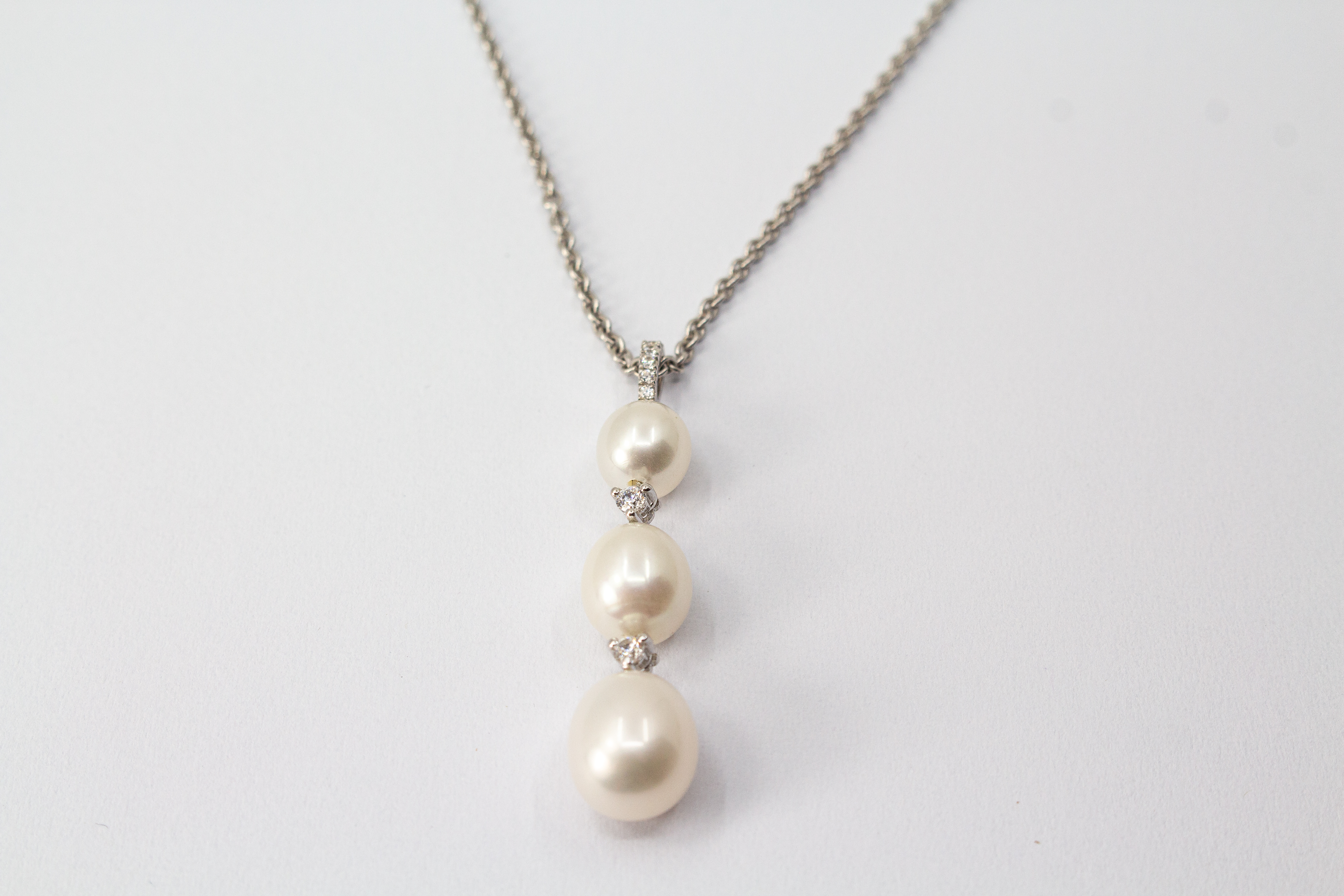 Hochwertiges Collier aus rhodiniertem 925er Sterlingsilber mit drei hängenden Süßwasserzuchtperlen und funkelnden Zirkonia-Zwischenelementen, Schmuckdesign von Regina Kraus