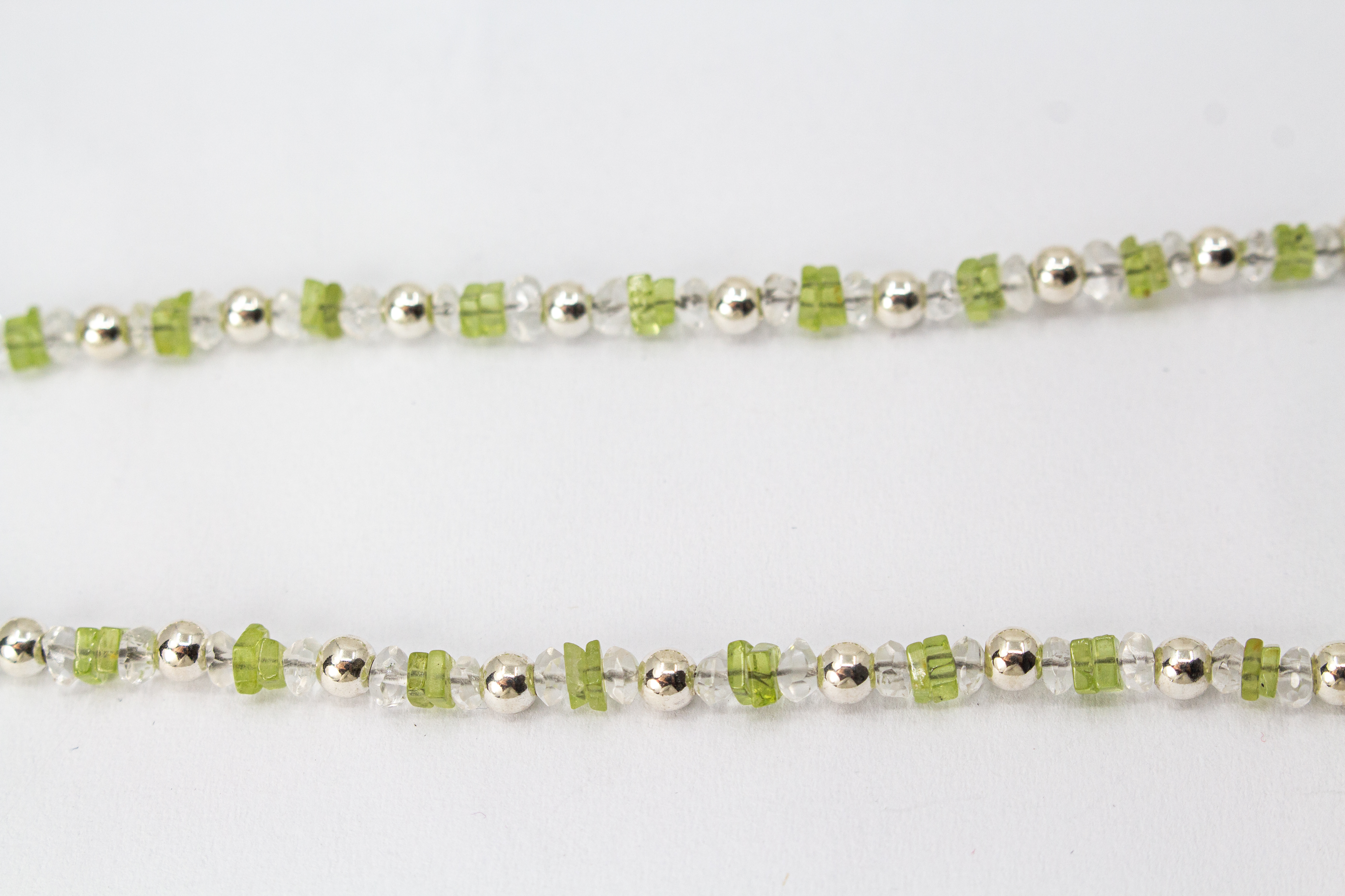 Filigrane Edelsteinhalskette aus hellgrünen Peridot-Splittern, klaren Bergkristall-Elementen und glänzenden 925 Sterling Silberkugeln aus dem Online-Shop der Goldschmiede Regina Kraus