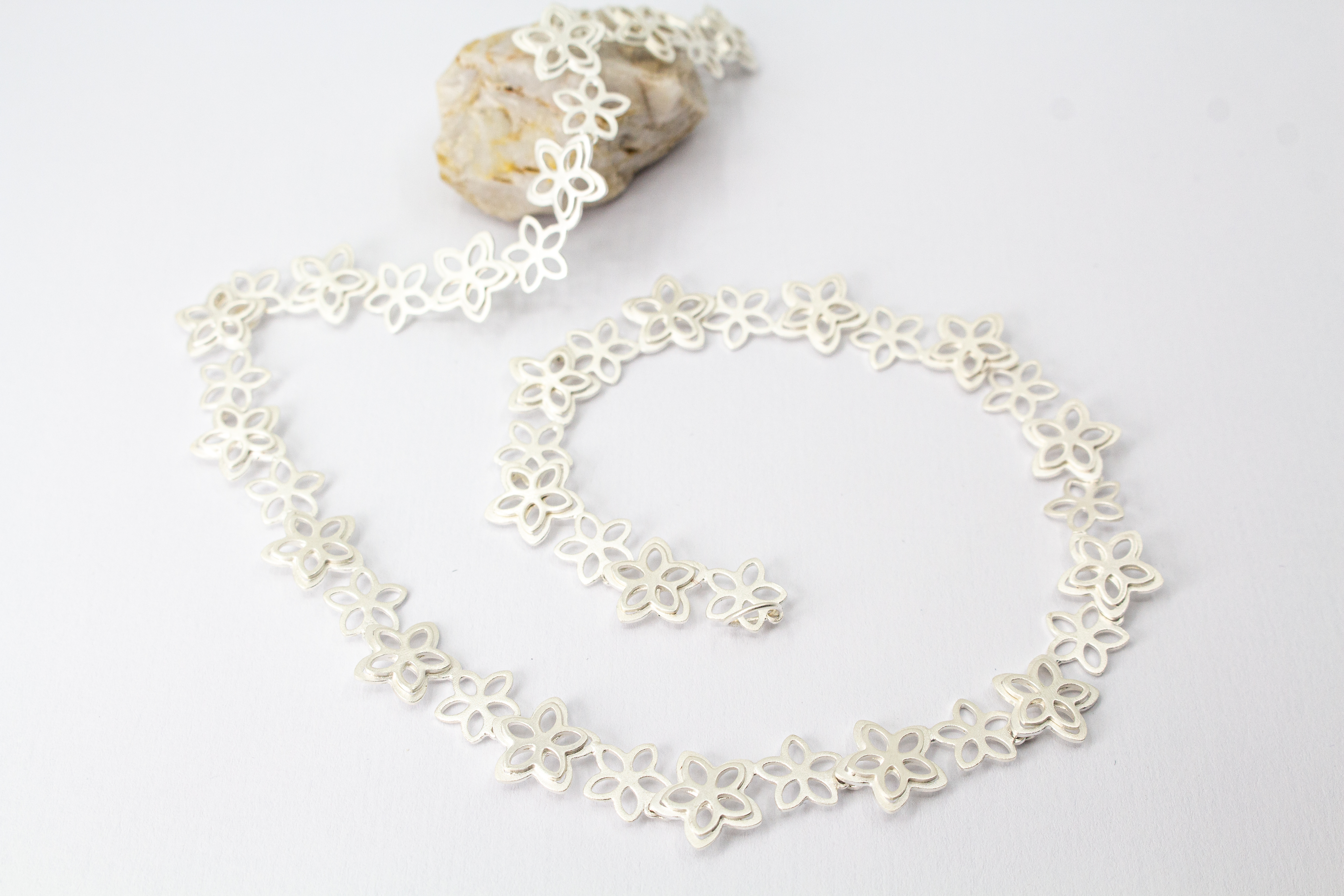 Filigranes Collier Rosalie aus der Goldschmiede Regina Kraus, gefertigt aus mattiertem 925er Sterling Silber mit aneinandergereihten, offenen Blüten-Motiven