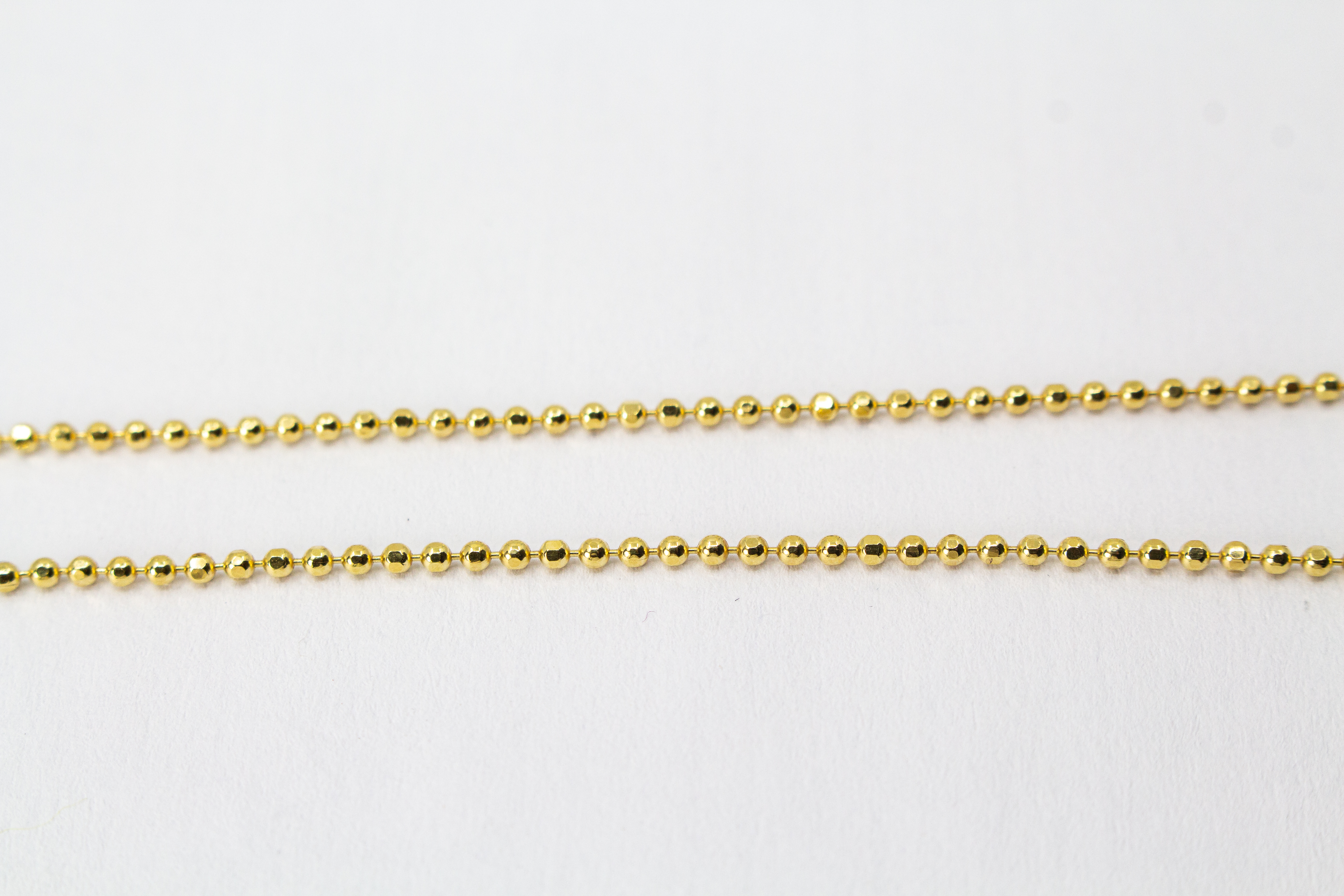Goldene Kugelkette aus 20 Mikron vergoldetem 925er Sterlingsilber mit rundem Plättchen-Anhänger „Feenstaub“, der eine ausgestanzte Fee zeigt, aus dem Onlineshop der Goldschmiede Regina Kraus.