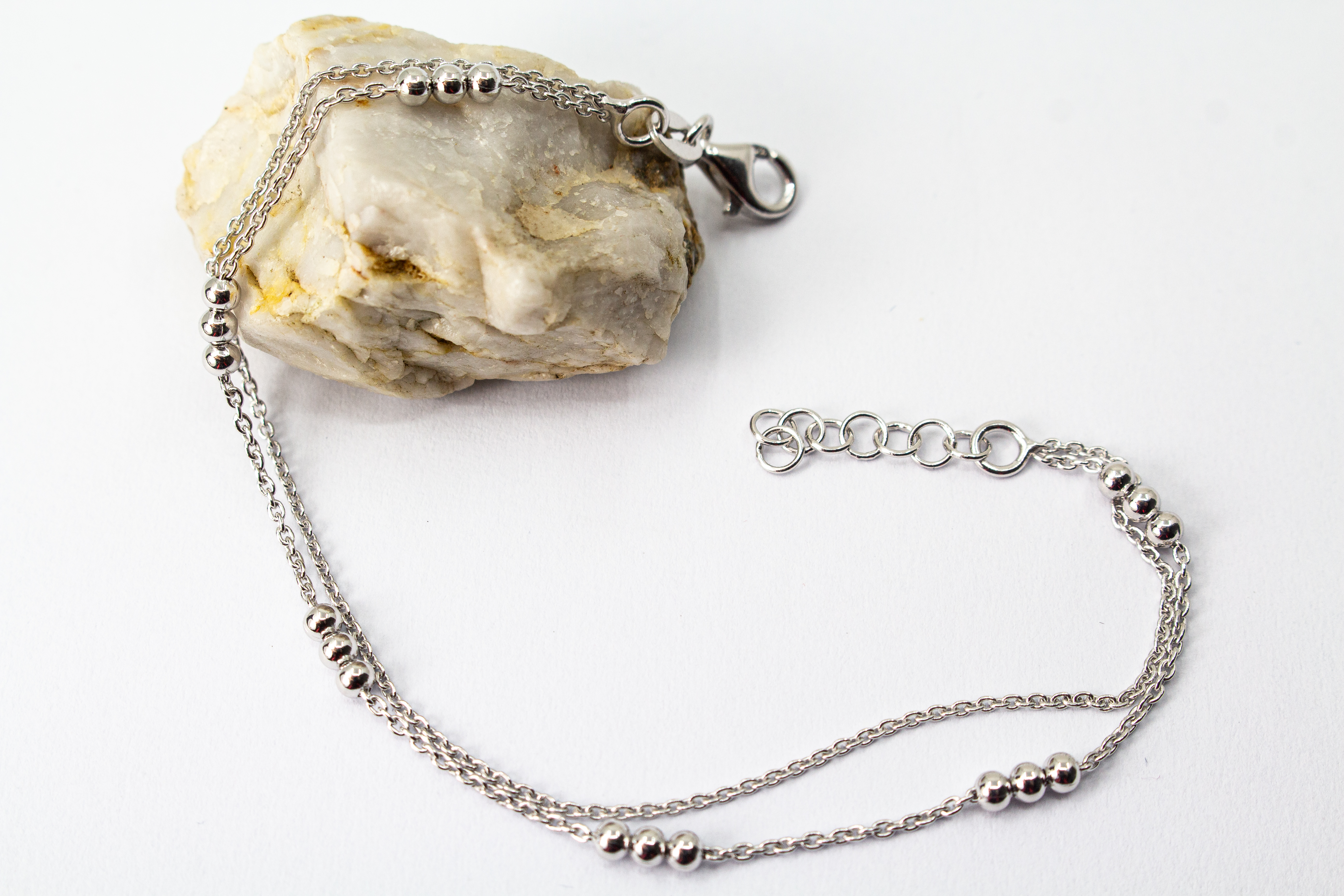 Zweireihiges Armband der Goldschmiede Regina Kraus aus hochwertigem rhodiniertem 925er Silber mit kleinen Silberkugeln in Dreiergruppen auf feinen Ankerketten.