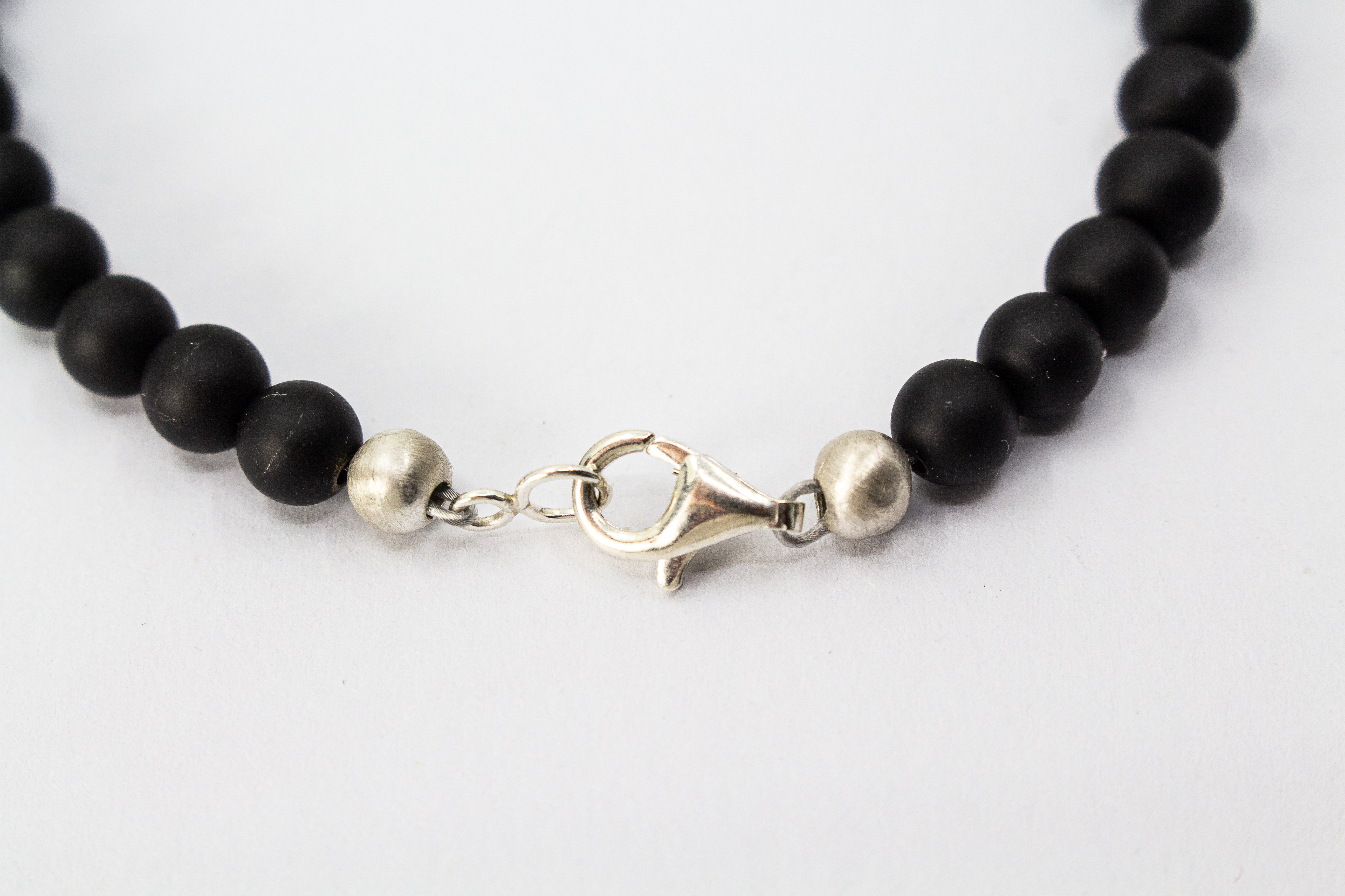 Herrenarmband „Dunkler Pol“ aus mattschwarzem Onyx mit markanten Zwischenteilen aus 925er Sterlingsilber.