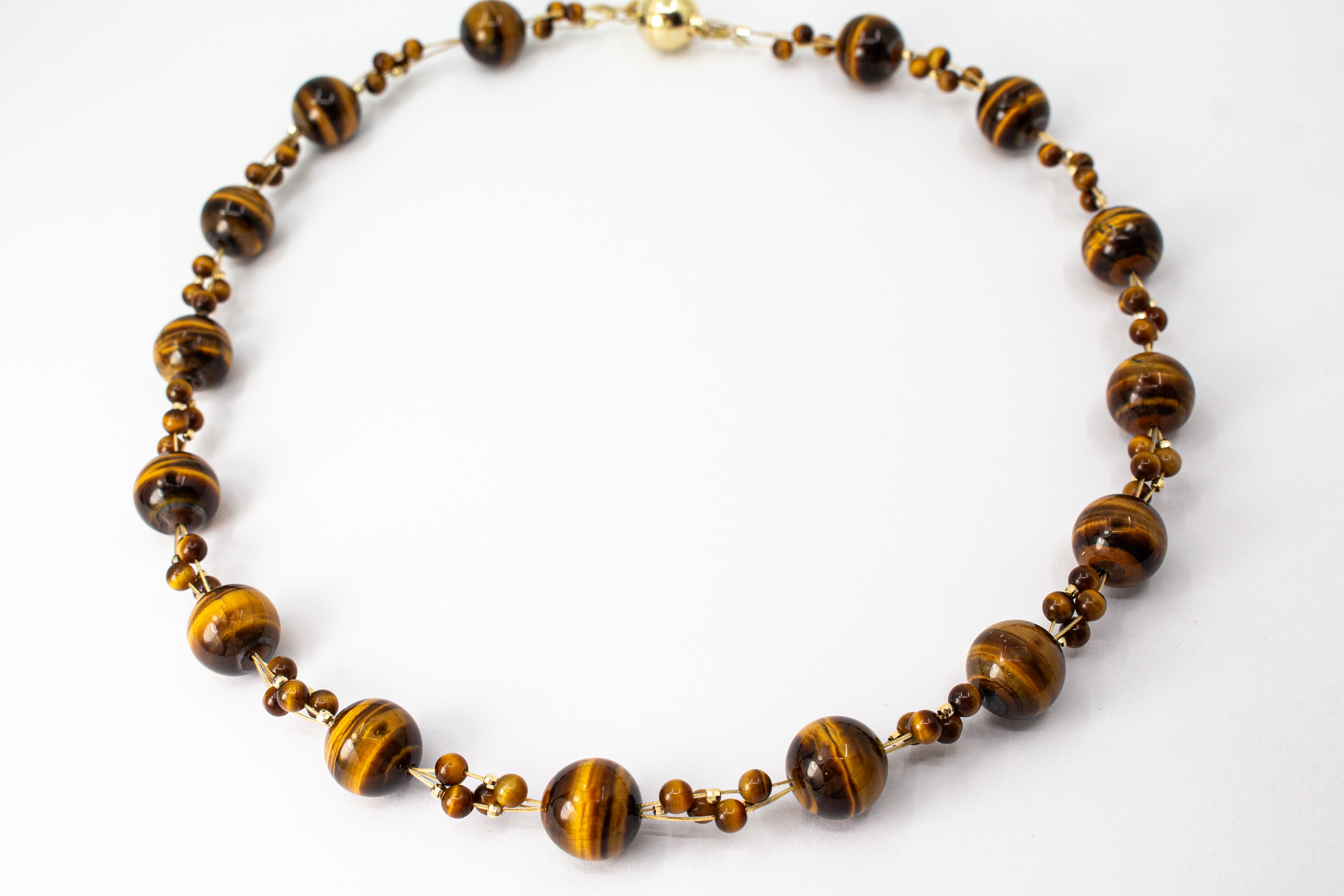 Eine handgefertigte Edelsteinkette der Goldschmiede Regina Kraus aus runden, braungoldenen Tigerauge-Perlen