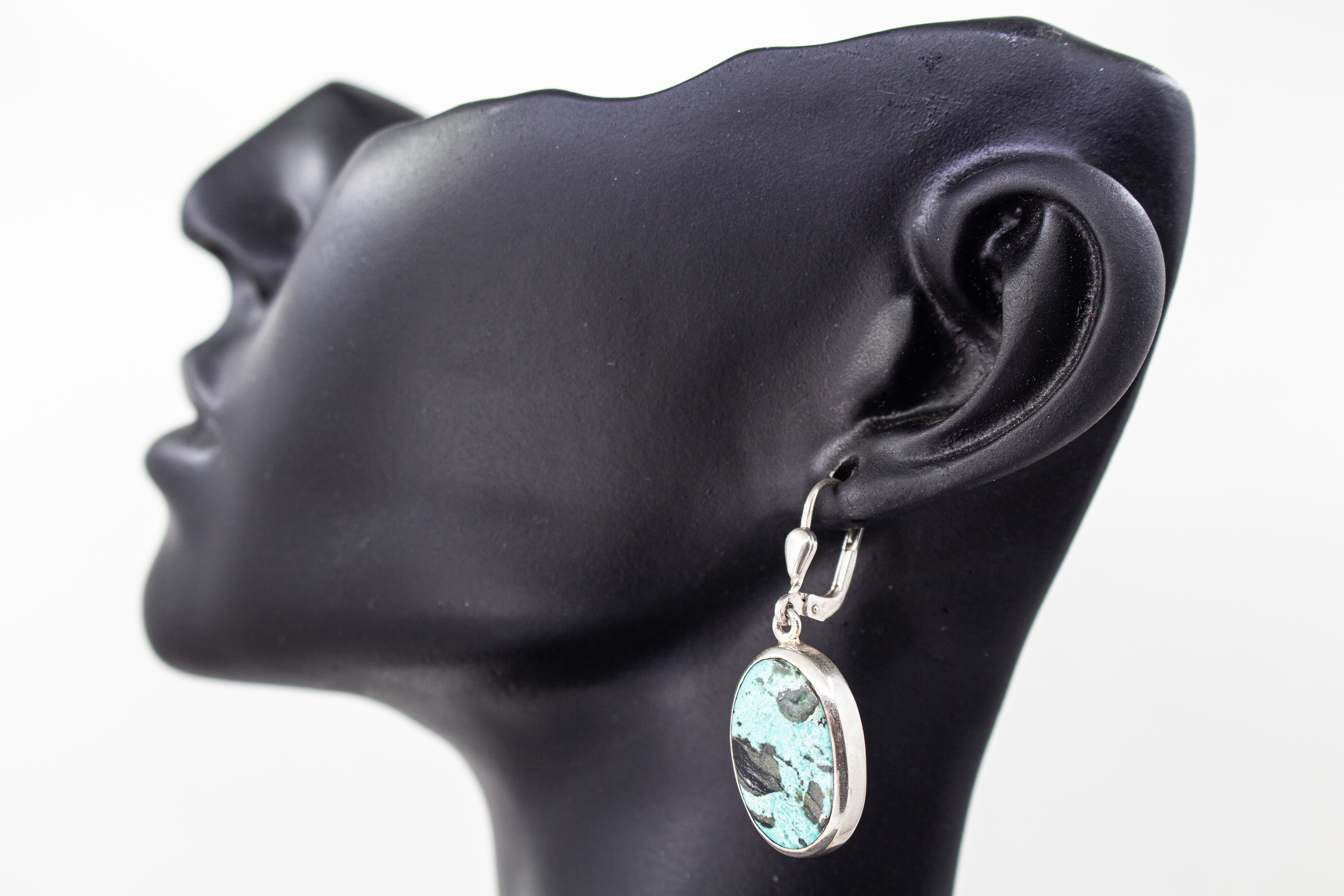 Elegante, hängende Ohrringe mit großen, ovalen Türkis-Edelsteinen in glatter Silberfassung an Klappbügeln (Brisuren) aus dem Online-Shop der Goldschmiede Regina Kraus.
