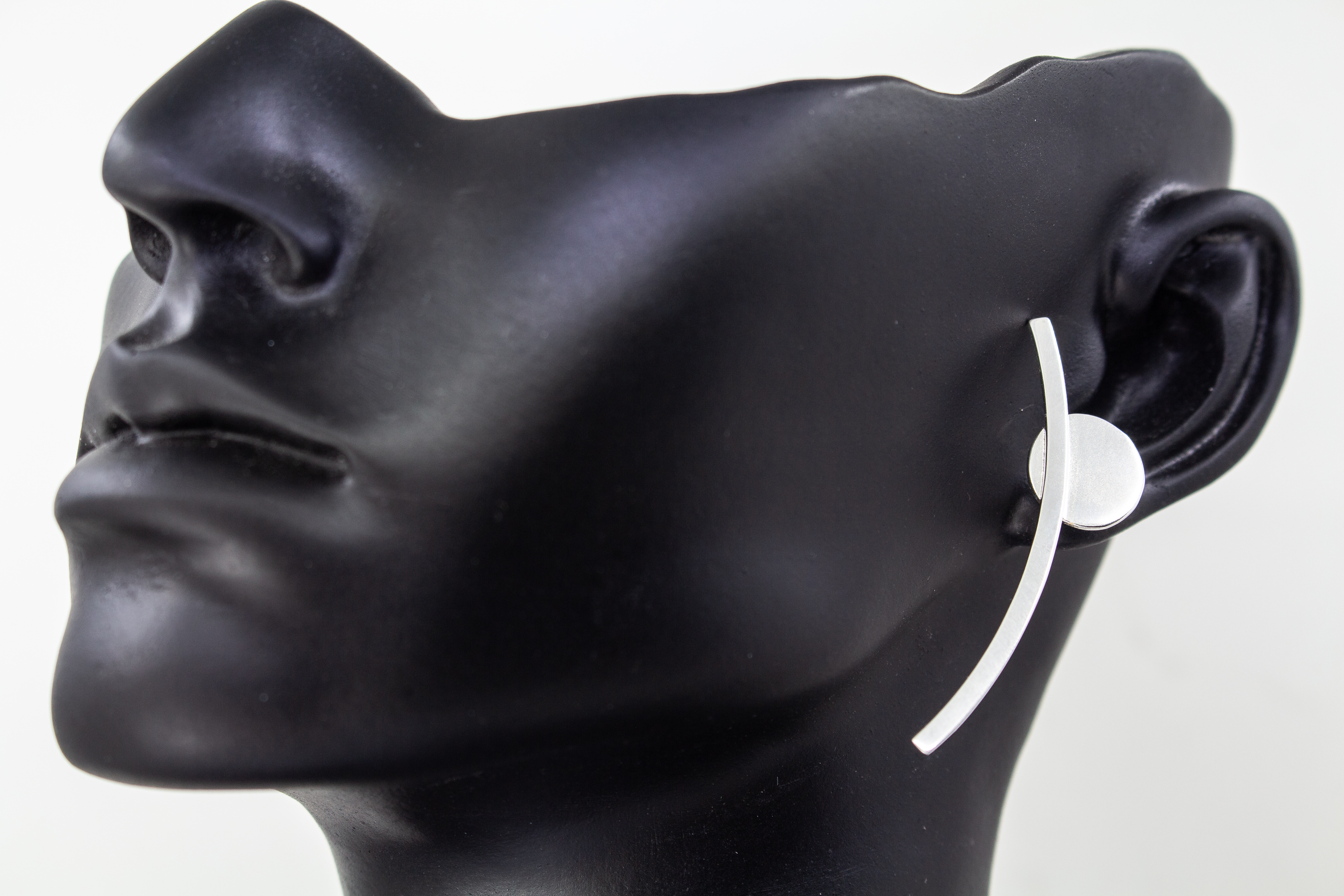 moderne, geometrische Ear Climber Ohrstecker aus glänzendem 925 Sterling Silber mit einer flachen Kreisscheibe und einem geschwungenen Silberstab aus dem Online-Shop der Goldschmiede Regina Kraus.