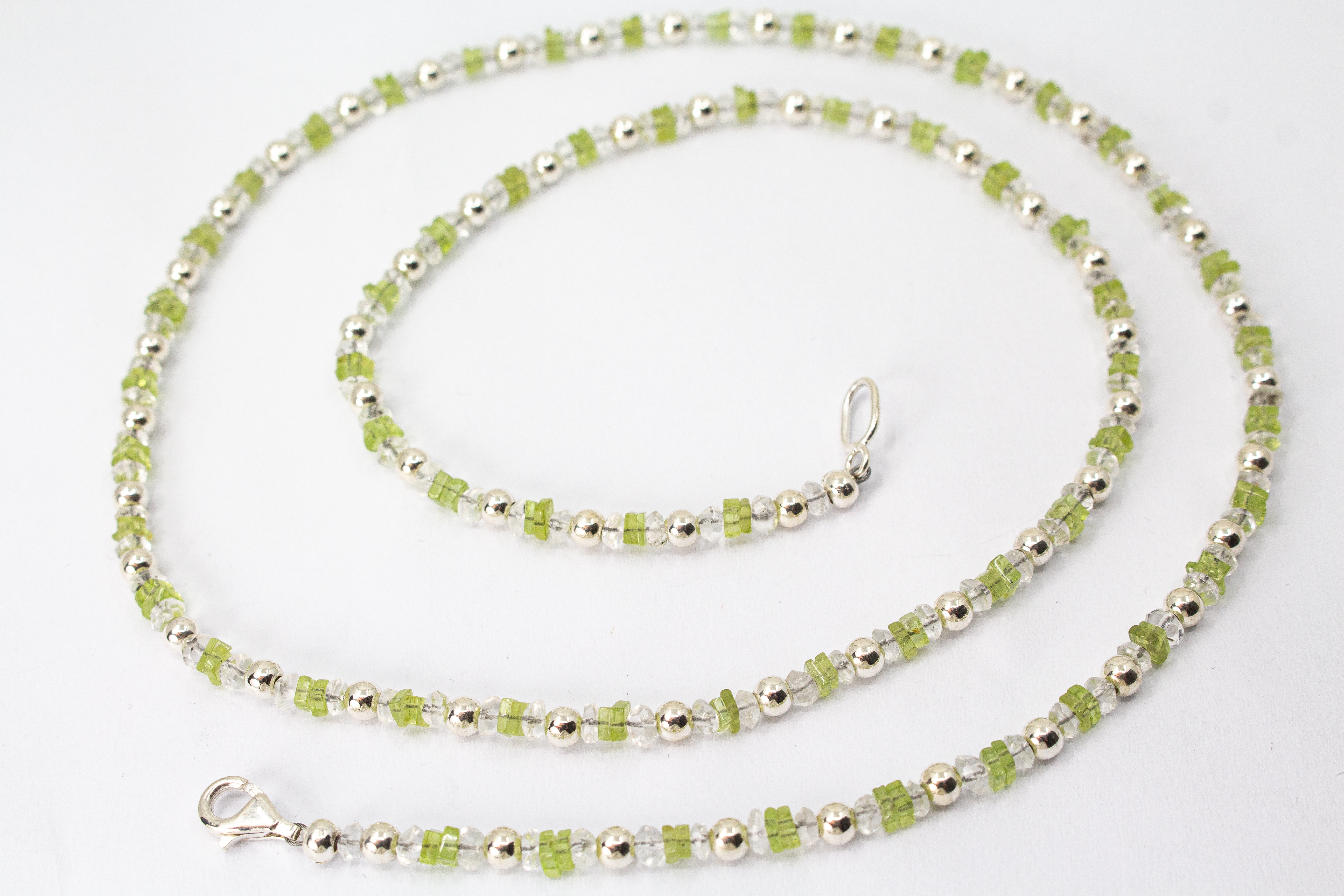 Filigrane Edelsteinhalskette aus hellgrünen Peridot-Splittern, klaren Bergkristall-Elementen und glänzenden 925 Sterling Silberkugeln aus dem Online-Shop der Goldschmiede Regina Kraus