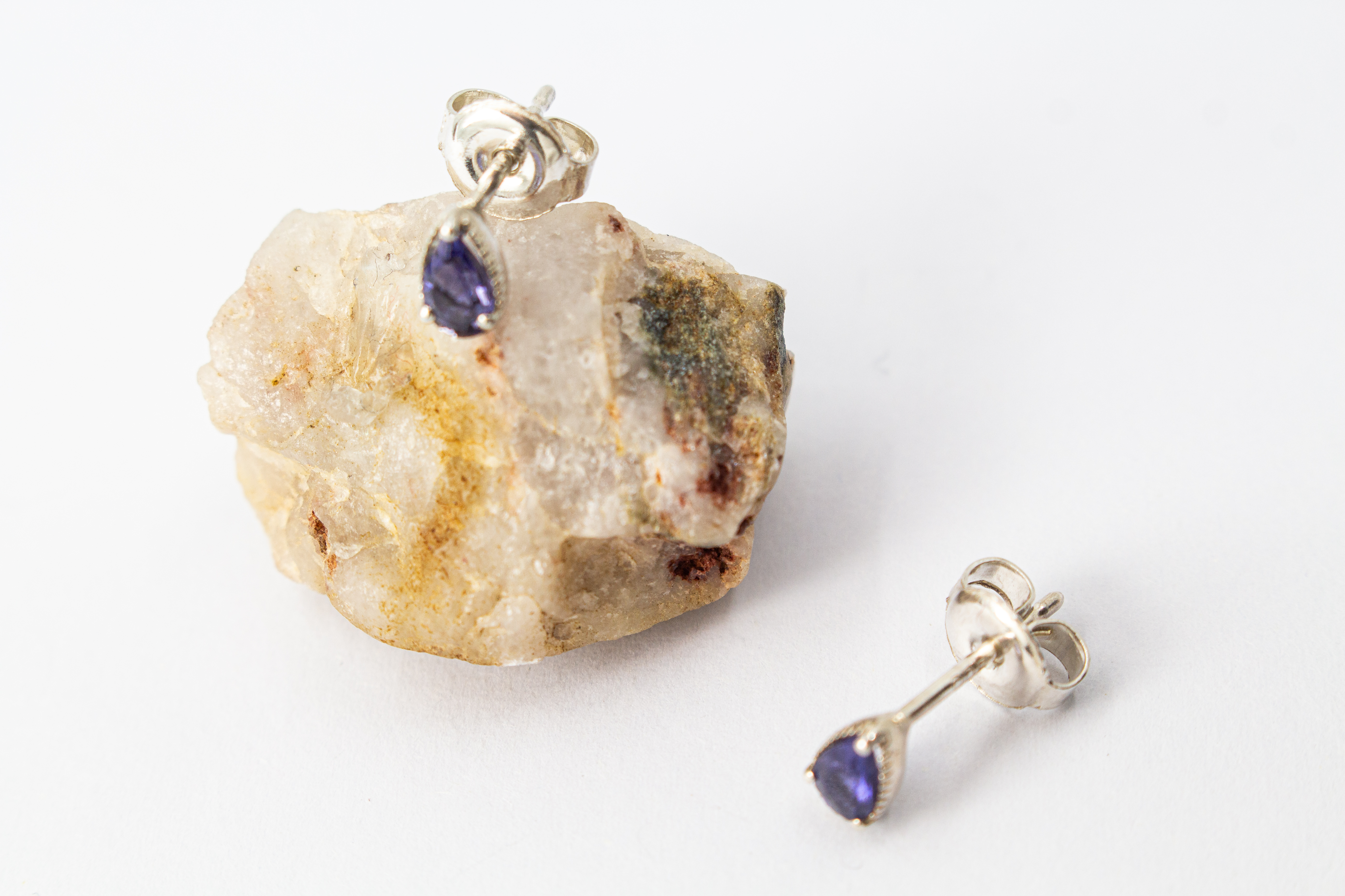 Paar filigrane Ohrstecker aus glänzendem 925 Sterling Silber mit kleinen, tropfenförmigen, blau-violetten Iolith-Edelsteinen in einer fein verzierten Fassung aus dem Online-Shop der Goldschmiede Regina Kraus.