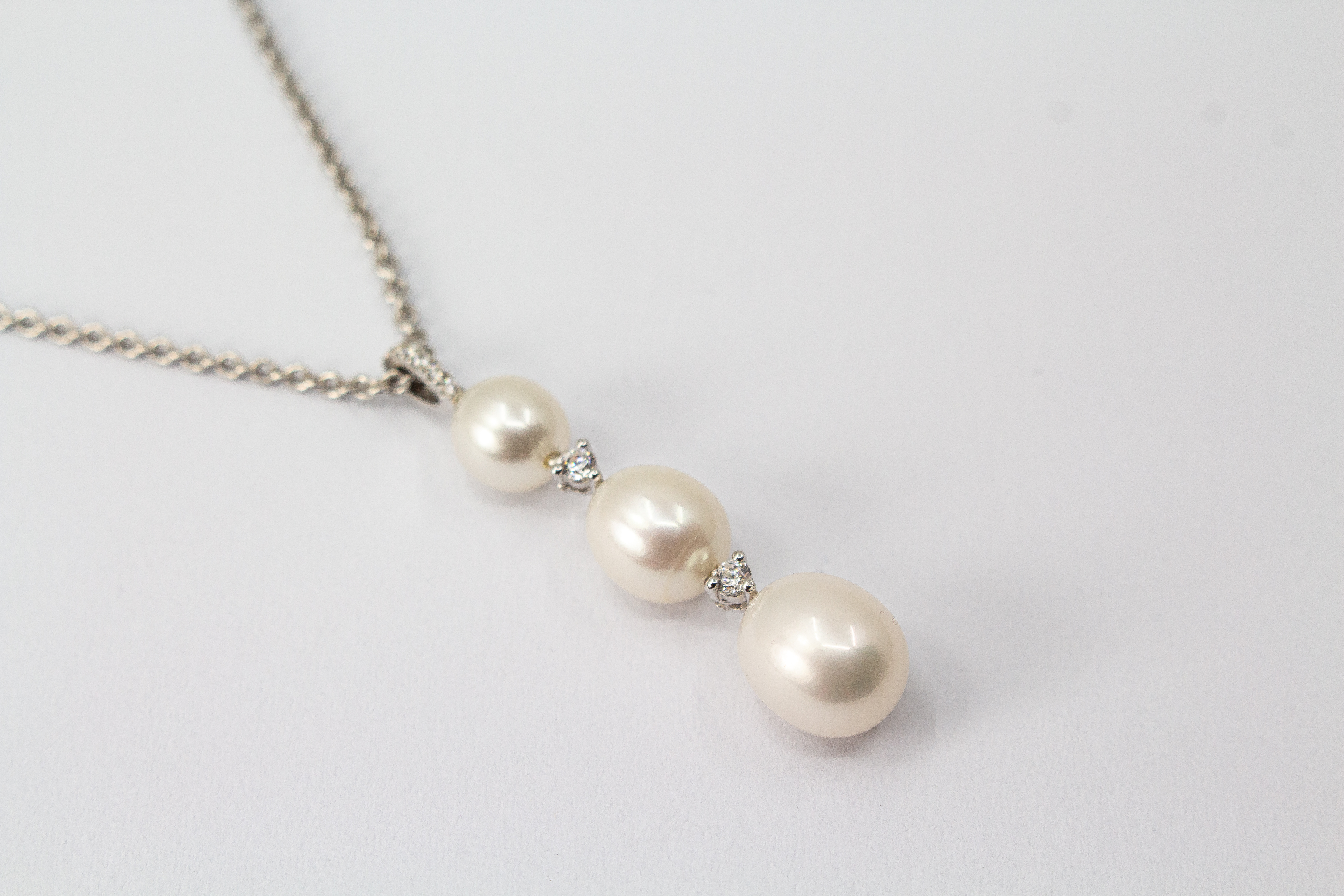Hochwertiges Collier aus rhodiniertem 925er Sterlingsilber mit drei hängenden Süßwasserzuchtperlen und funkelnden Zirkonia-Zwischenelementen, Schmuckdesign von Regina Kraus