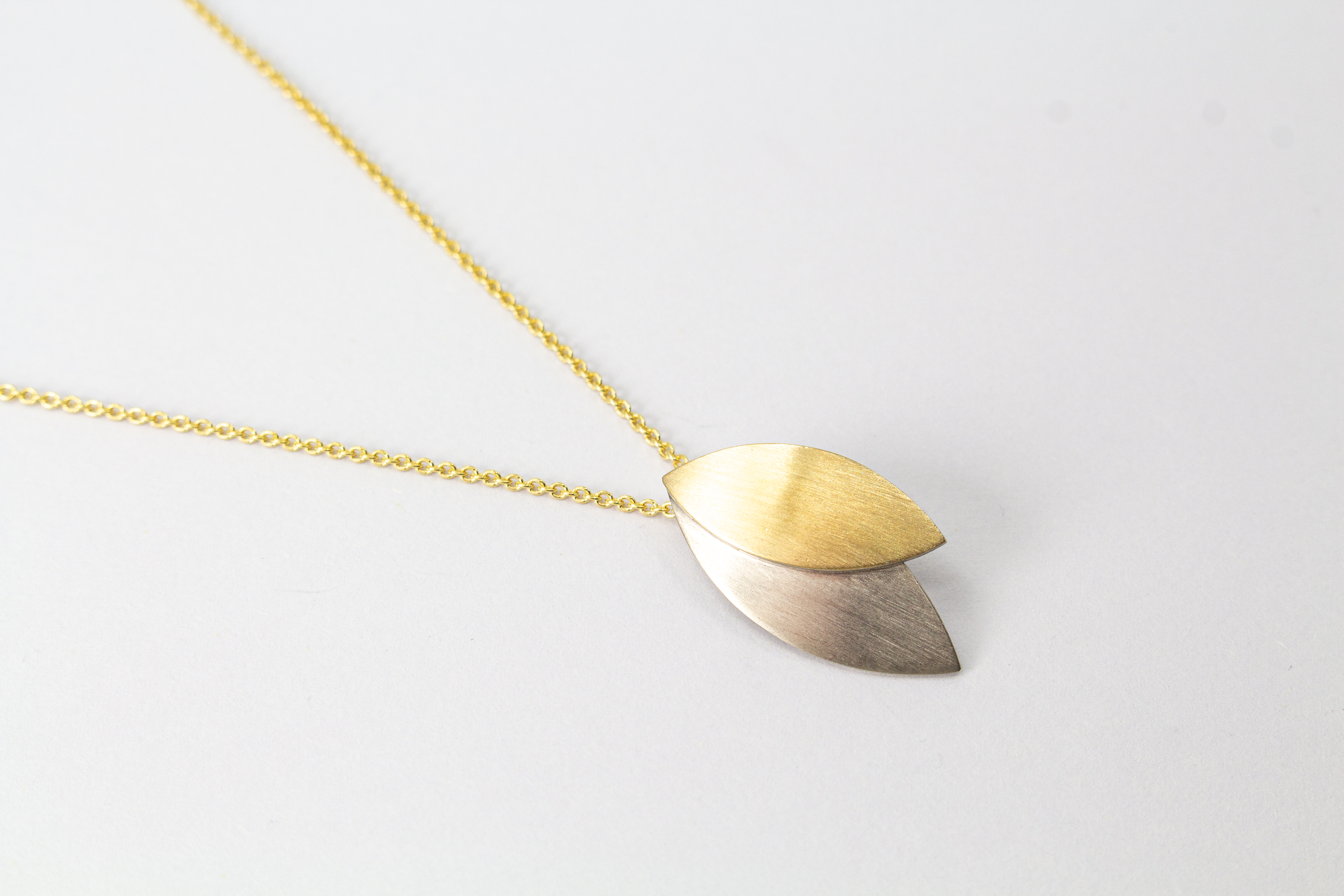 Kette „Blattgold“ aus 925er Sterlingsilber mit Feingoldbelötung und zweifarbigem Anhänger in filigraner Blattform.