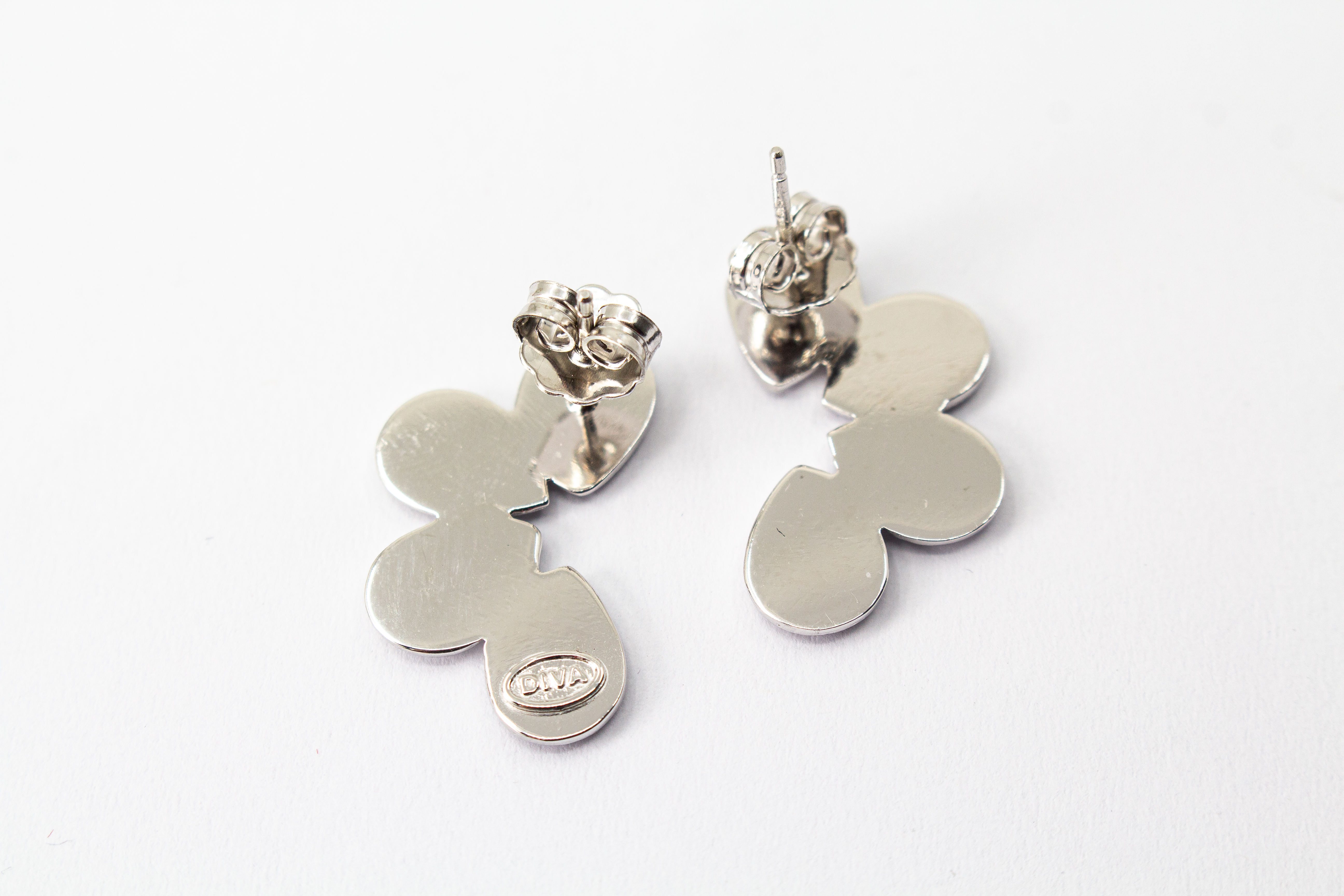 Moderne Ohrstecker der Cosmic Drop Serie von Diva Gioielli aus rhodiniertem 925 Silber. Die Ohrringe zeigen eine fächerförmige Anordnung von glatten und punktförmig strukturierten Tropfen