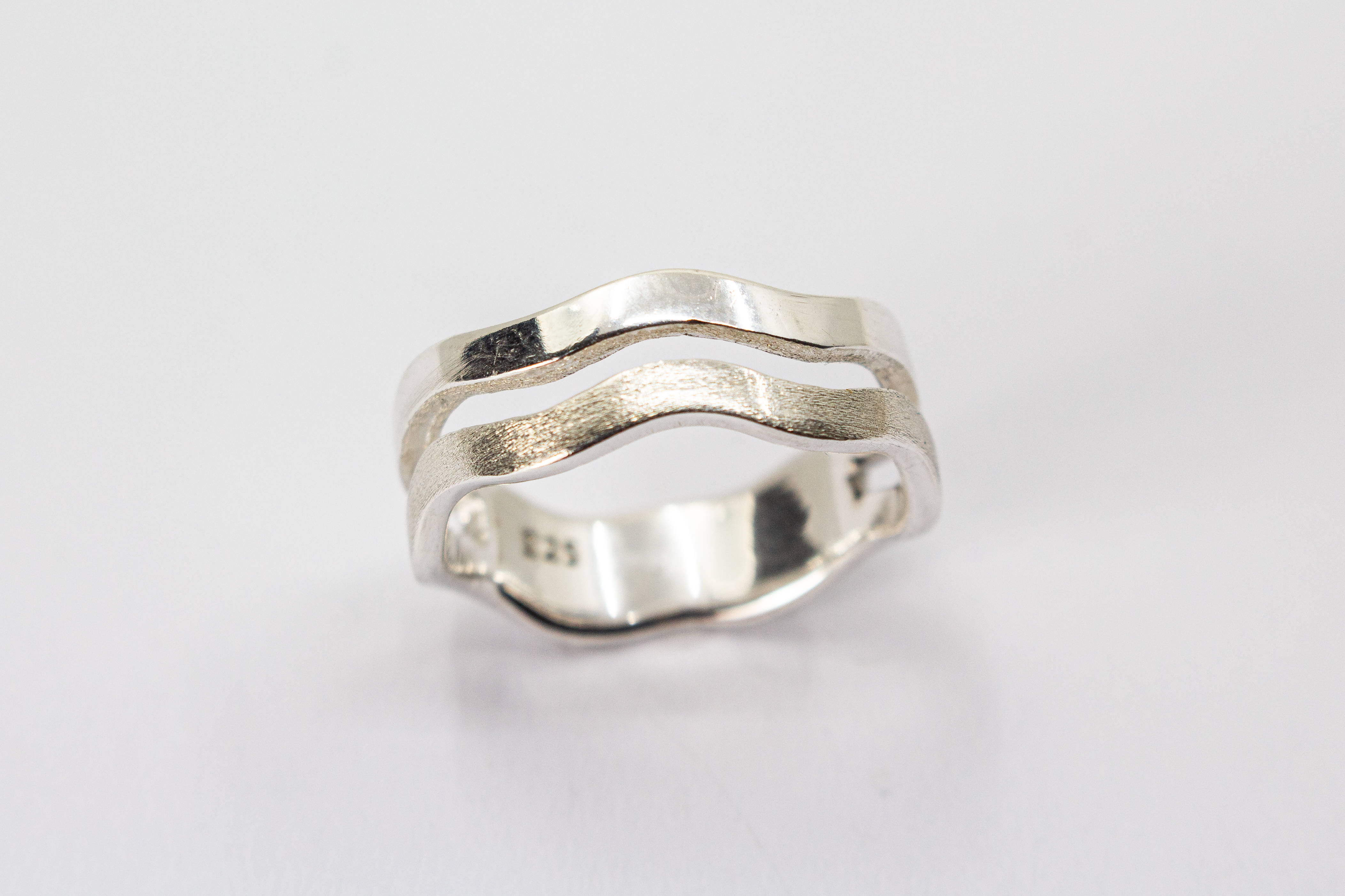 Ausgefallener Ring aus 925er Silber in zweireihiger Wellenoptik mit einer eismattierten Struktur-Schiene und einer glänzend polierten Schiene im Onlineshop von Goldschmiede Regina Kraus.