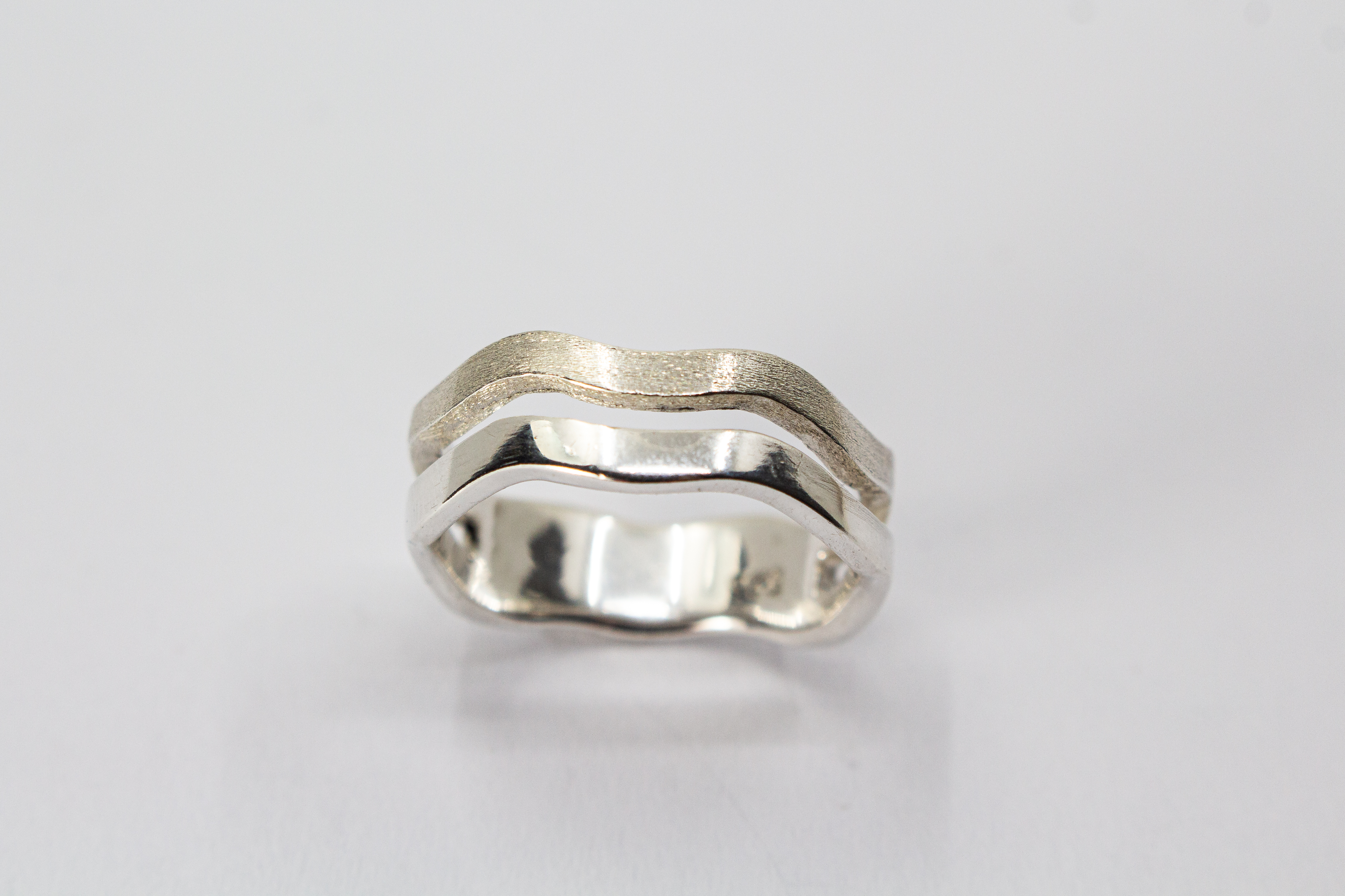 Ausgefallener Ring aus 925er Silber in zweireihiger Wellenoptik mit einer eismattierten Struktur-Schiene und einer glänzend polierten Schiene im Onlineshop von Goldschmiede Regina Kraus.