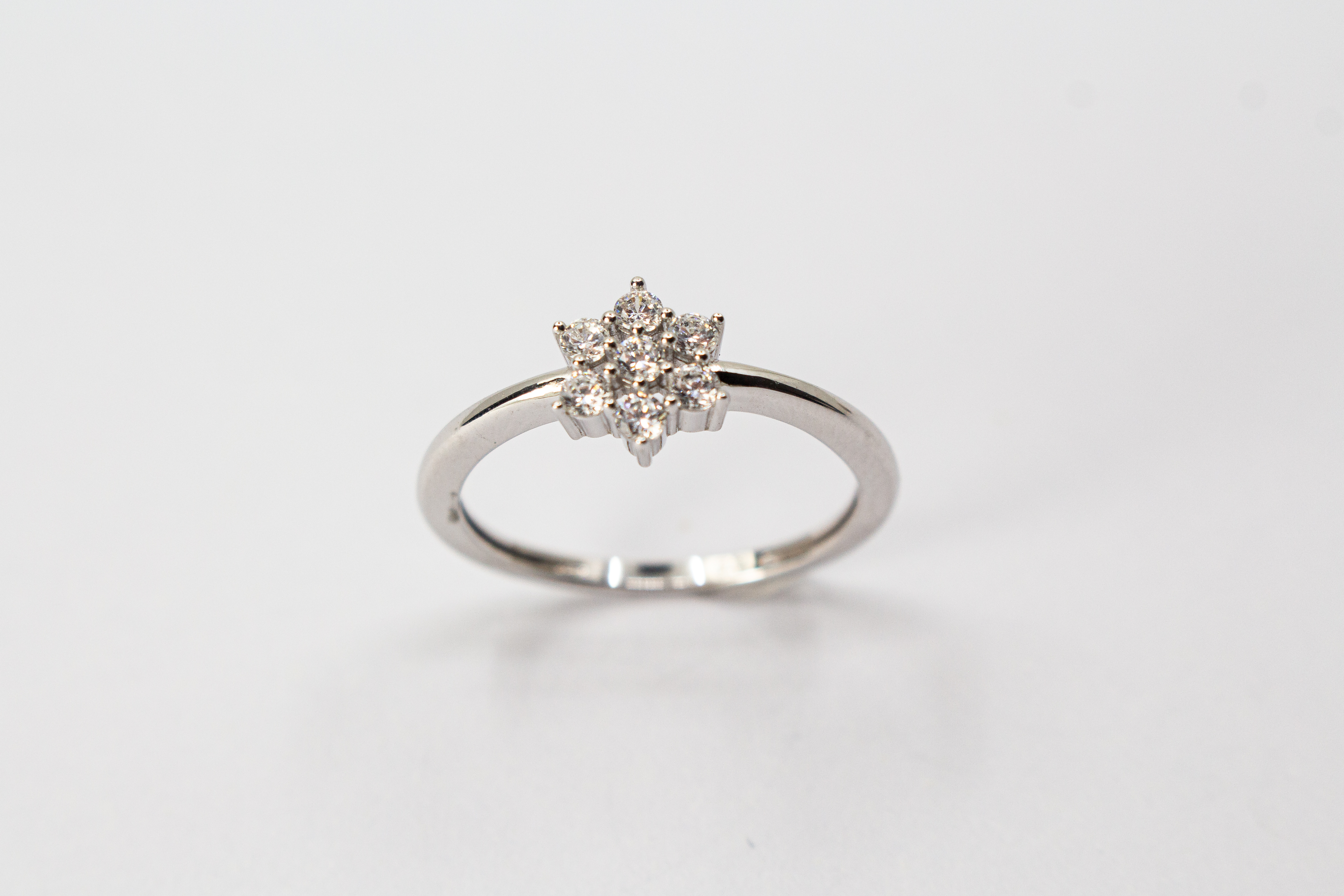 Rhodinierter 925er Sterlingsilber Ring „Schneestern“ mit funkelnden Zirkonia in sternförmiger Anordnung.