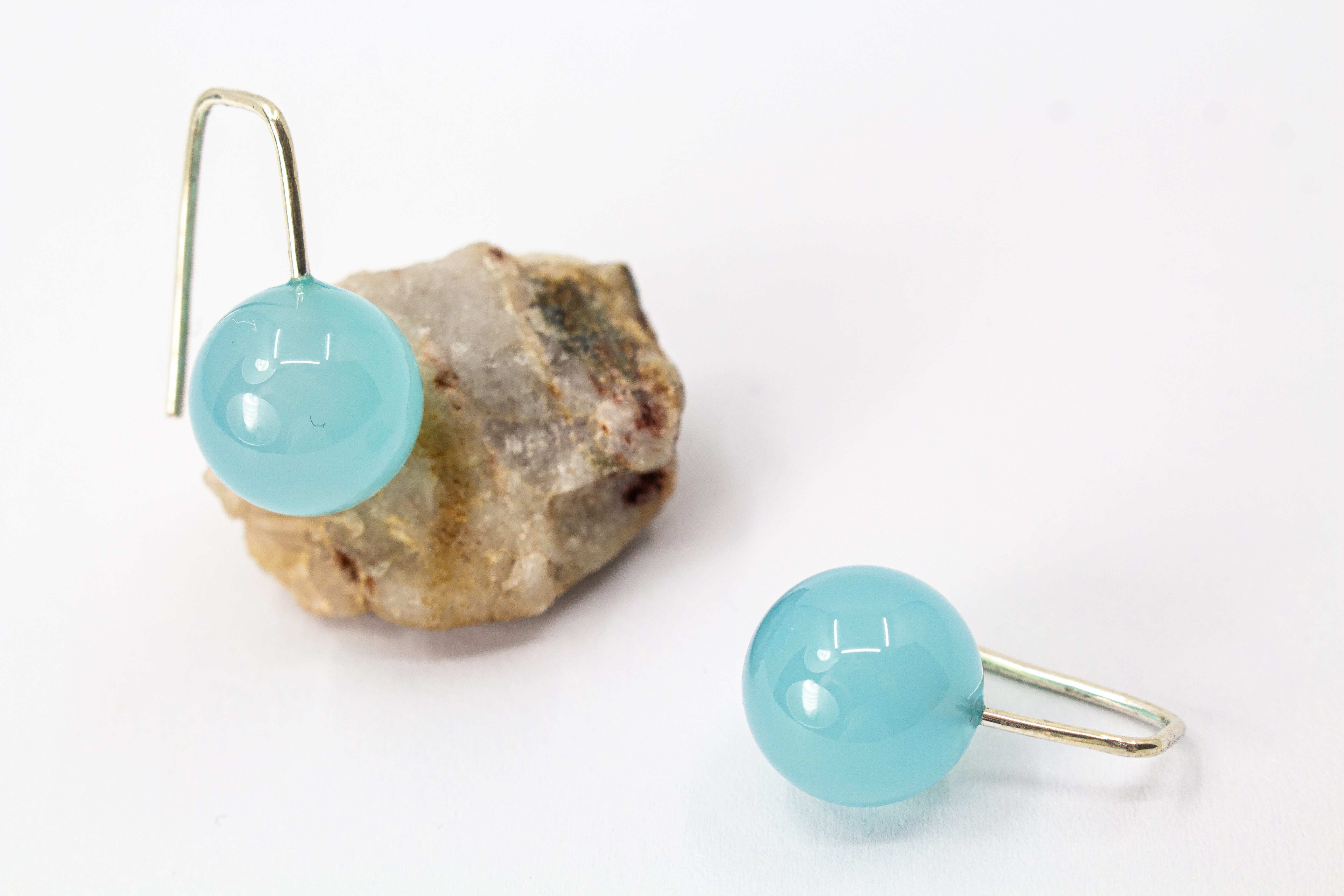 Minimalistische Ohrhänger aus feinen 925 Sterling Silberbügeln mit je einer glatten, hellblauen Chalcedon-Edelsteinkugel aus dem Online-Shop der Goldschmiede Regina Kraus
