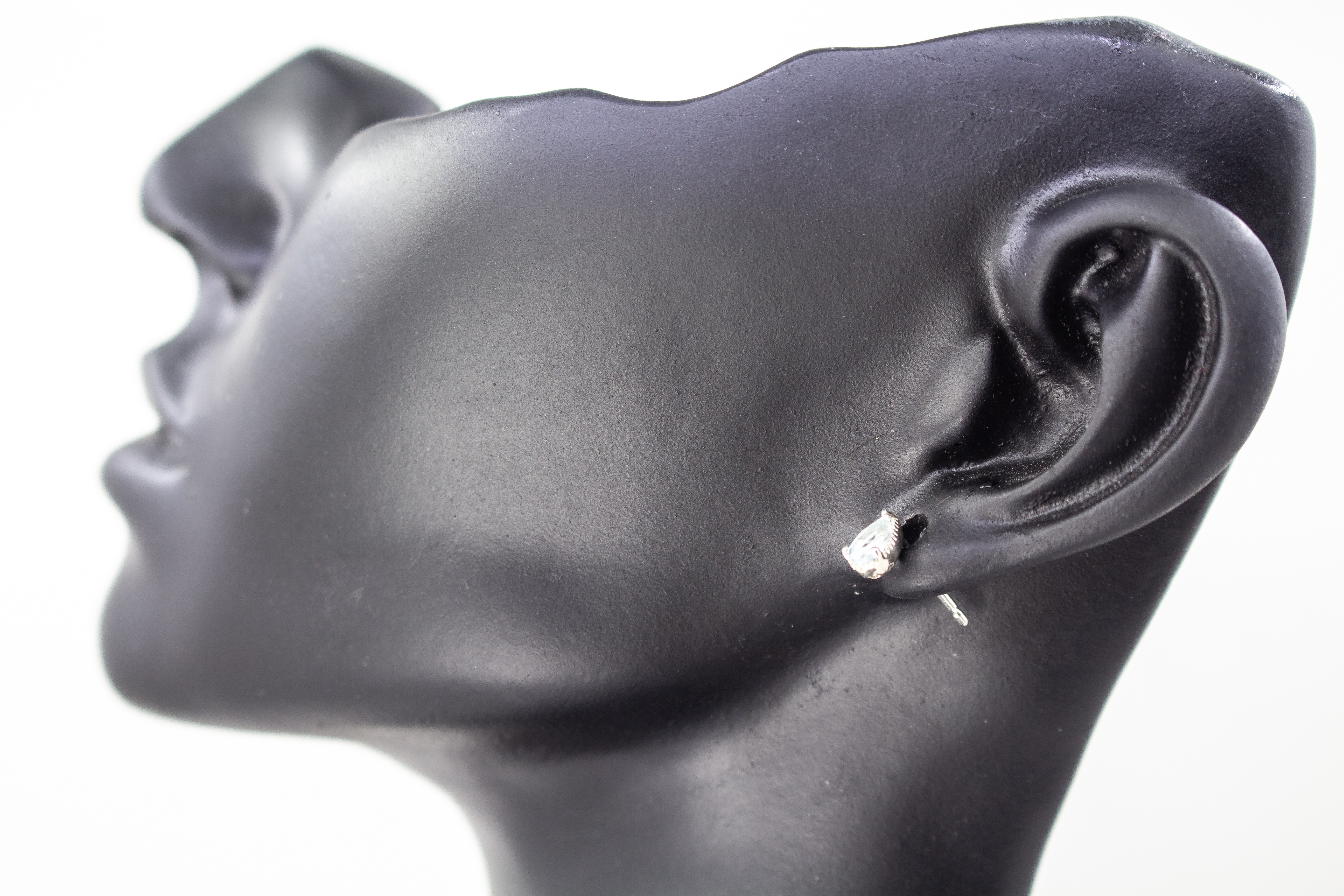 filigrane Ohrstecker aus glänzendem 925 Sterling Silber mit kleinen, tropfenförmigen, hellblauen Topas-Edelsteinen in einer fein verzierten Krappenfassung aus dem Online-Shop der Goldschmiede Regina Kraus.