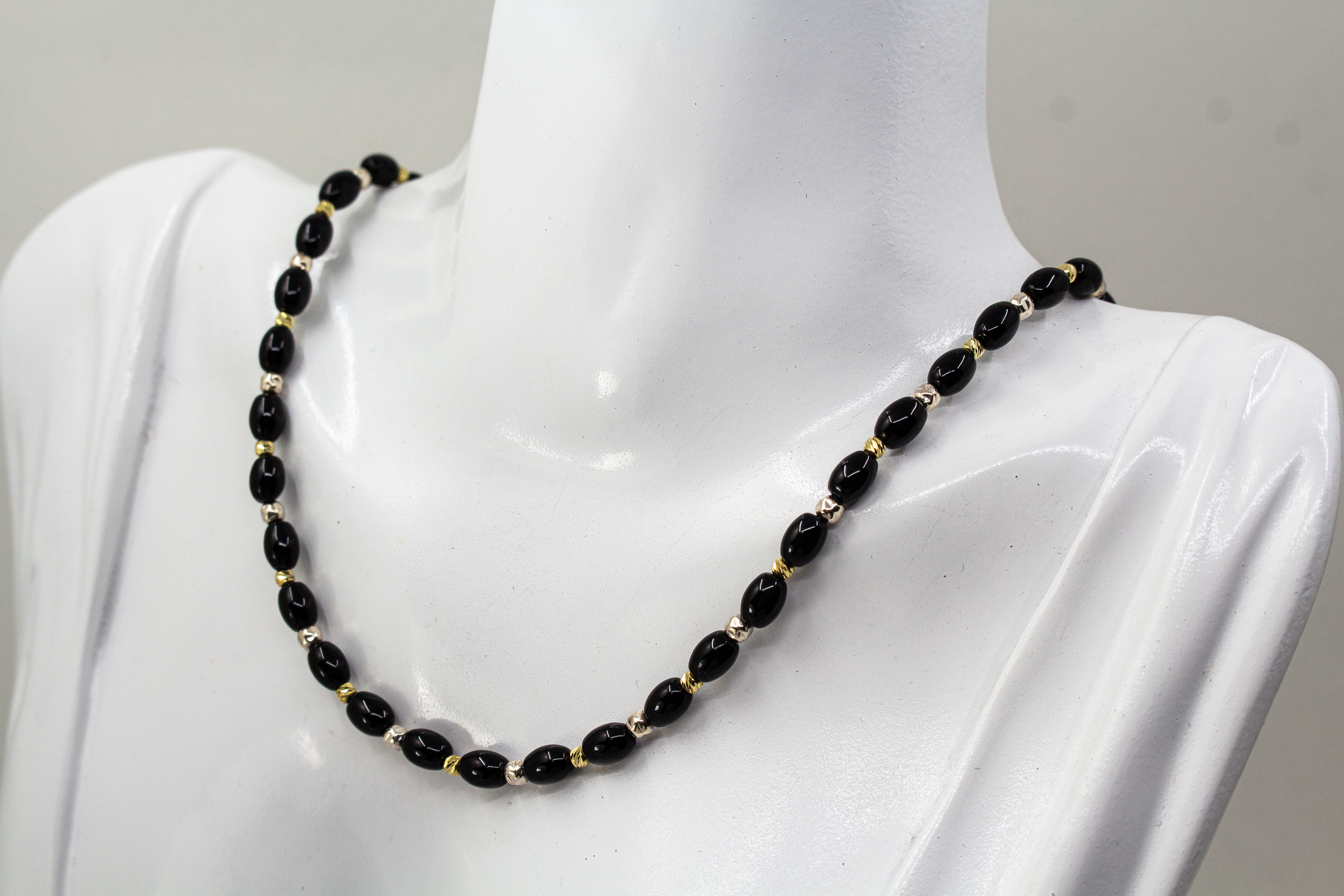 Elegante Onyx Kette „Mitternachtsglanz“ mit schwarzen Onyx-Perlen, Zwischenteilen aus 925er Sterlingsilber und vergoldeten Silberdetails.