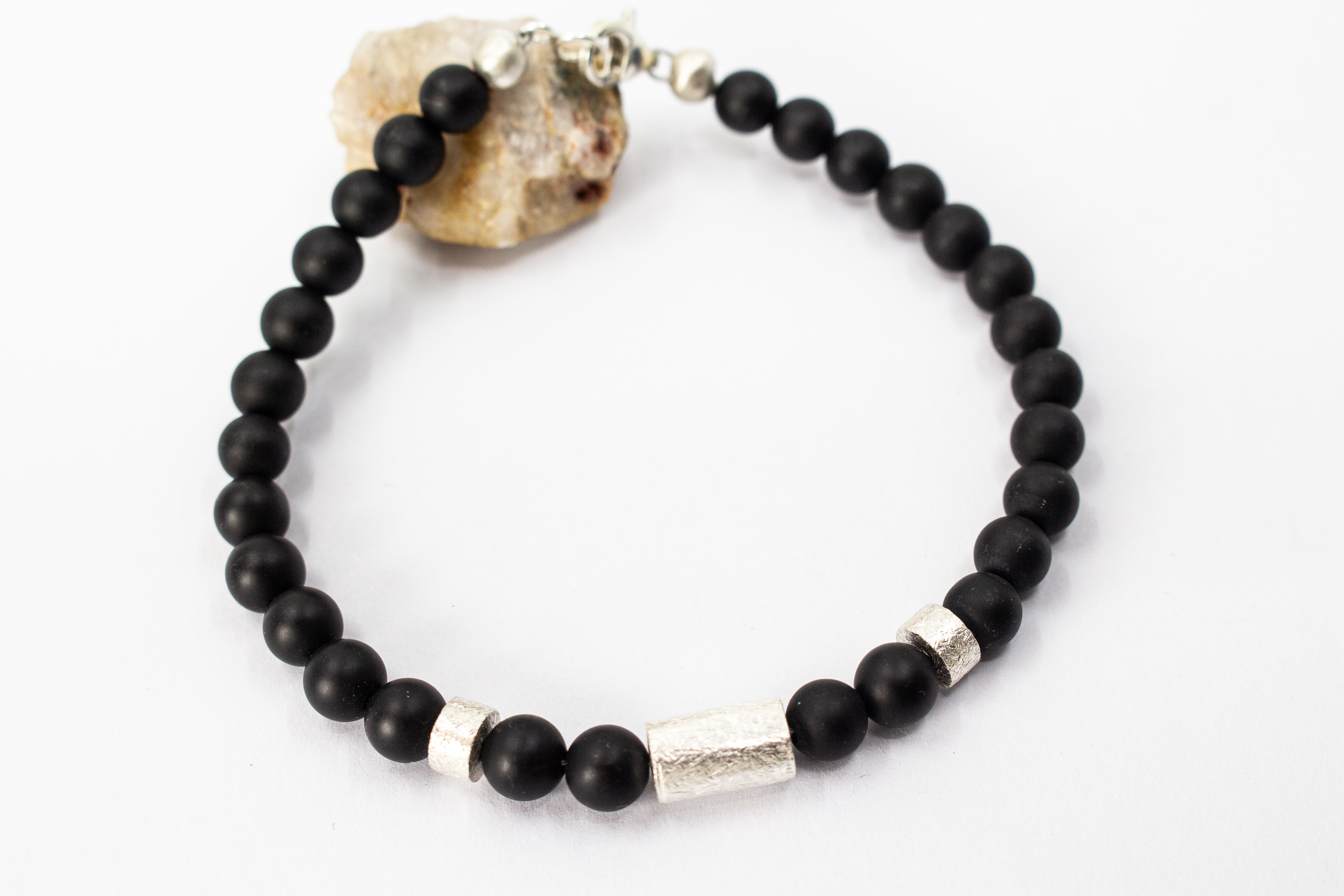 Herrenarmband „Dunkler Pol“ aus mattschwarzem Onyx mit markanten Zwischenteilen aus 925er Sterlingsilber.