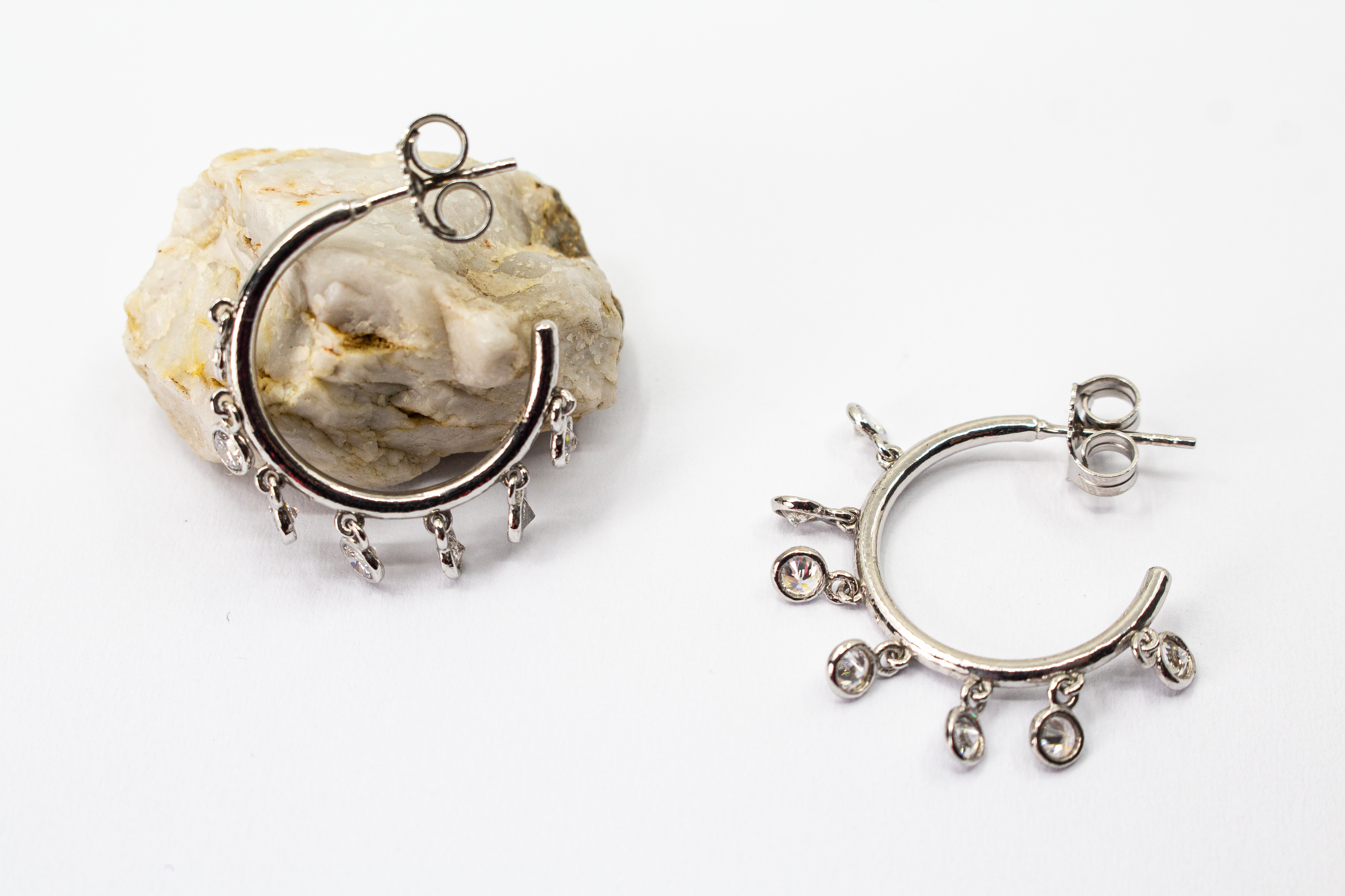 Elegante Creolen-Ohrstecker aus rhodiniertem 925er Silber mit mehreren funkelnden, beweglich angebrachten Zirkonia-Steinen von Goldschmiede Regina Kraus.