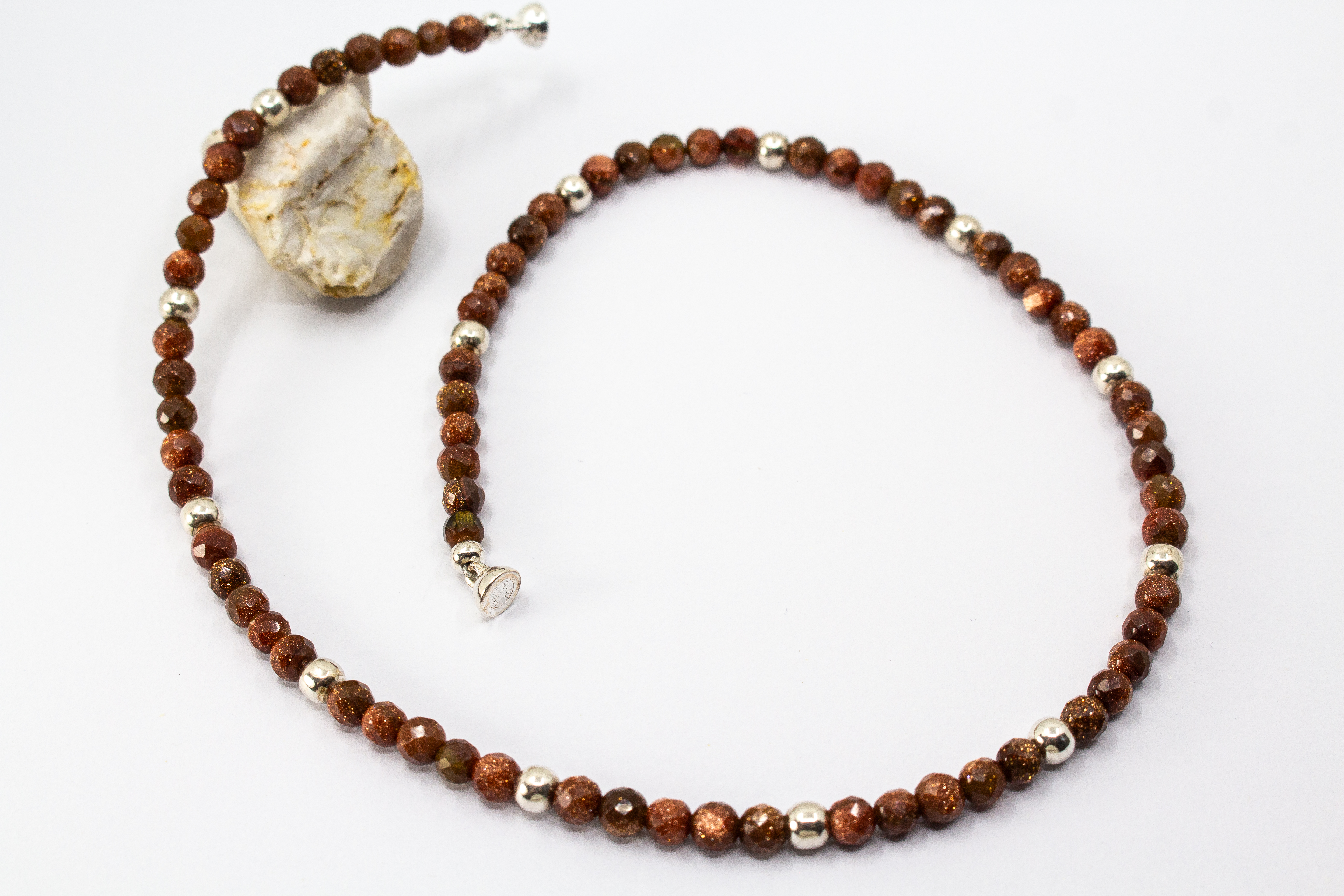 Collier „Goldflimmer“ aus facettiertem Goldfluss mit glänzenden Zwischenteilen aus 925er Sterlingsilber und funkelndem Goldschimmer.