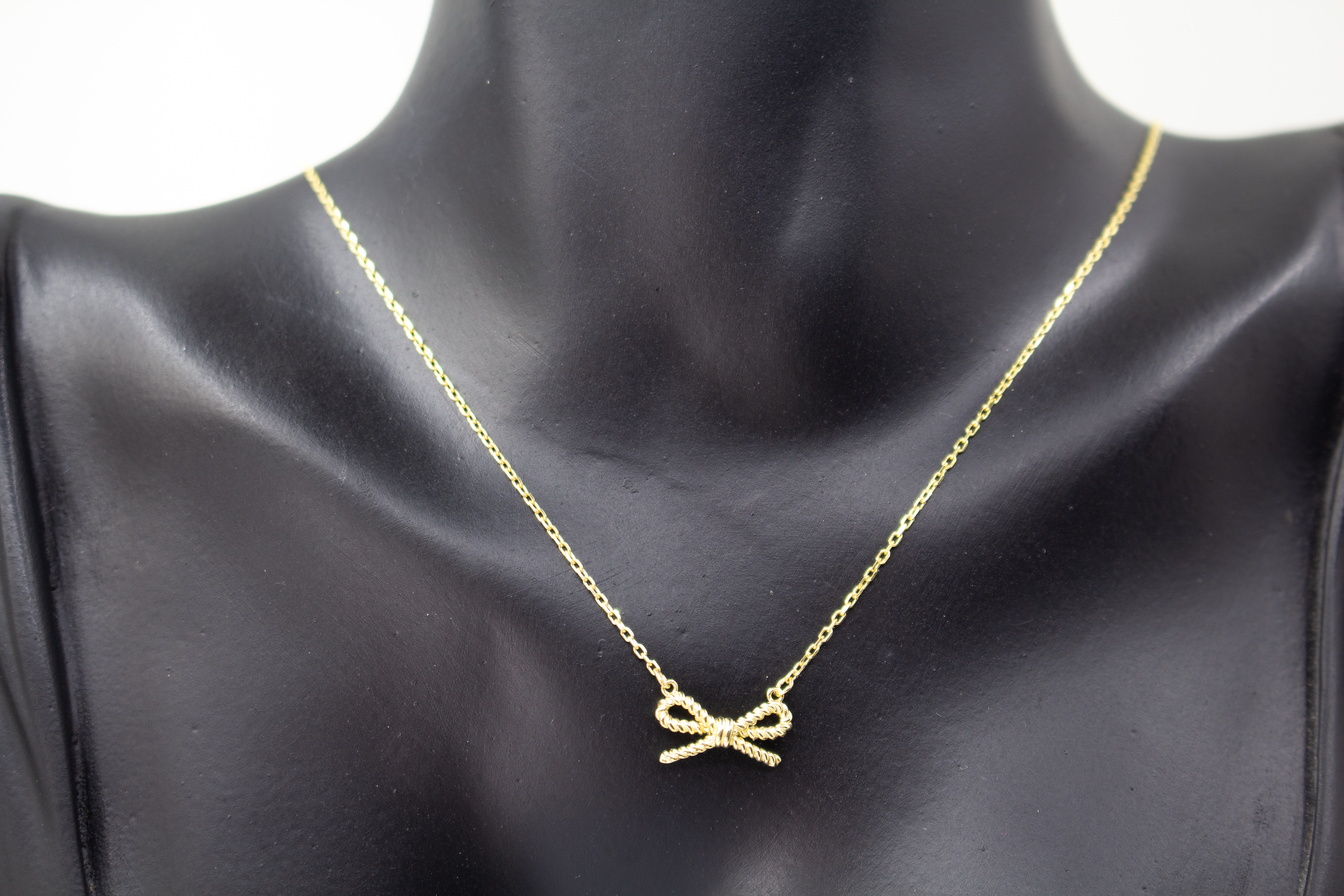 Collier „Schleifenzauber“ aus vergoldetem 925er Sterlingsilber mit filigranem Schleifenanhänger in elegantem, zeitlosem Design.