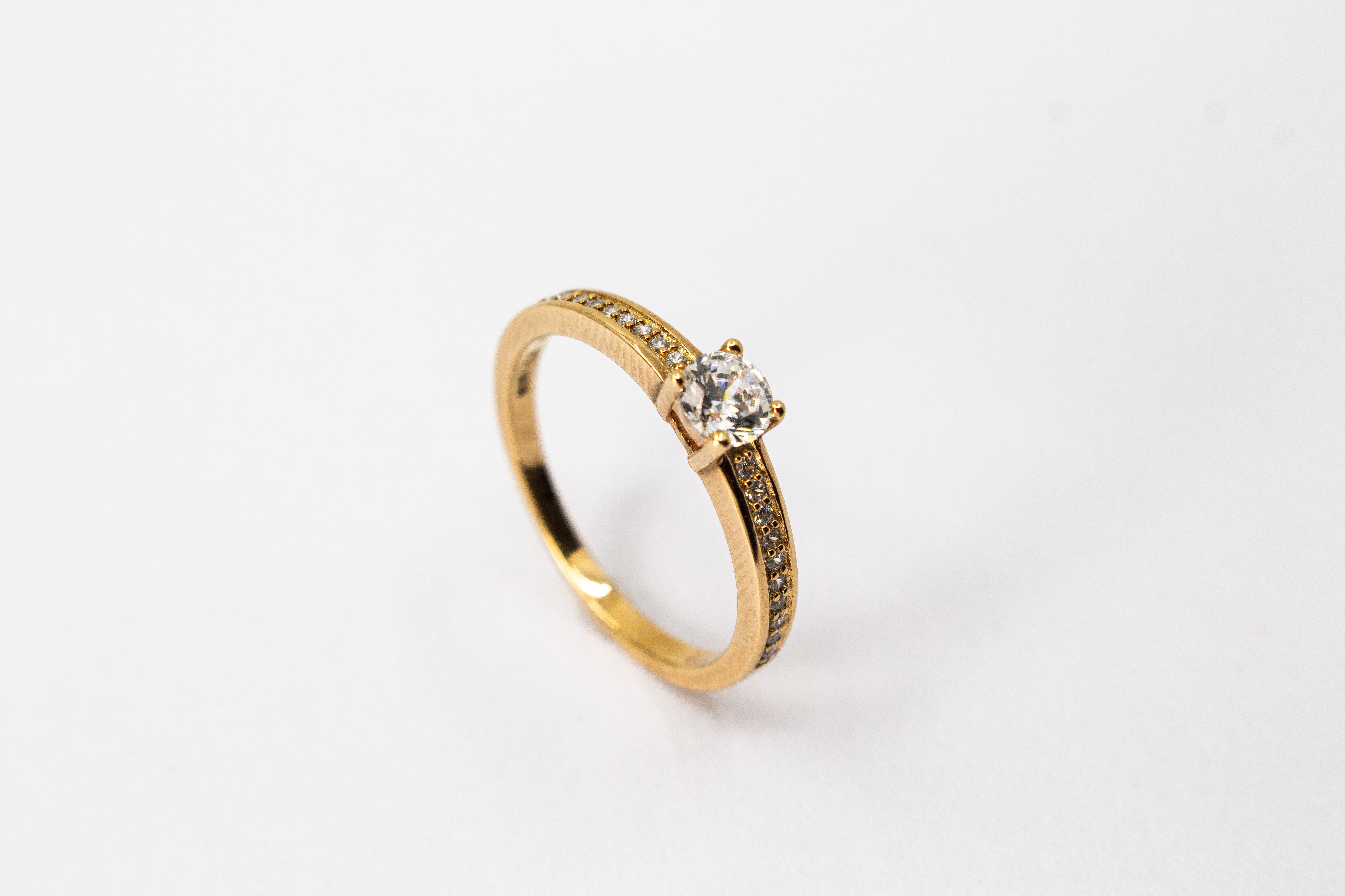 Eleganter Damenring aus rosévergoldetem 925 Sterling Silber mit einem großen, rund facettierten Zirkonia-Hauptstein in einer klassischen Vier-Krappenfassung und einer mit kleinen Zirkoniasteinen im Pavé-Stil besetzten Ringschiene aus dem Online-Shop der G