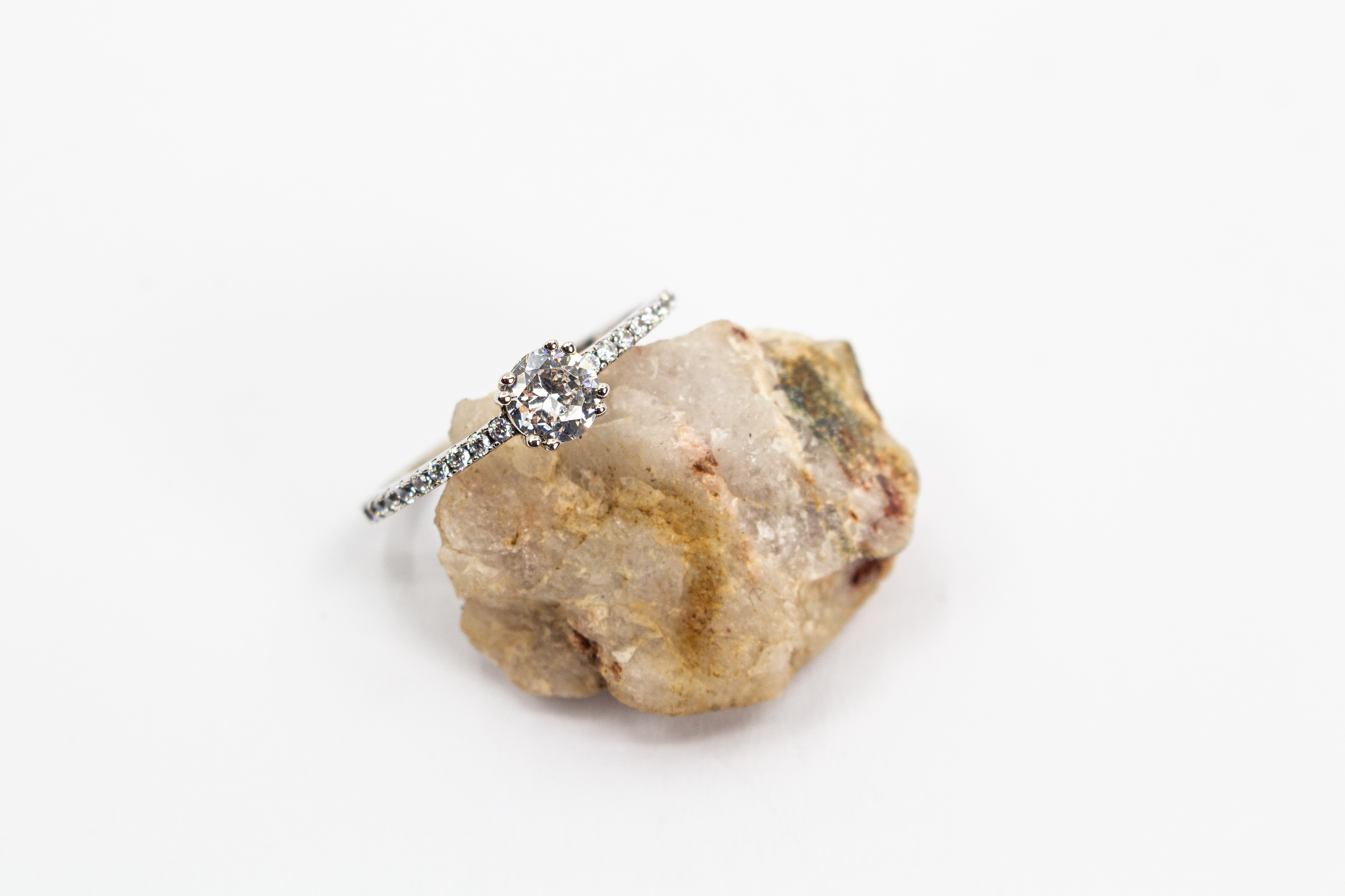Eleganter Solitärring aus rhodiniertem 925er Silber mit einem großen, in einer Vierer-Krappenfassung gehaltenen Zirkonia und einer mit kleinen Zirkoniasteinen besetzten Ringschiene im Onlineshop von Goldschmiede Regina Kraus.