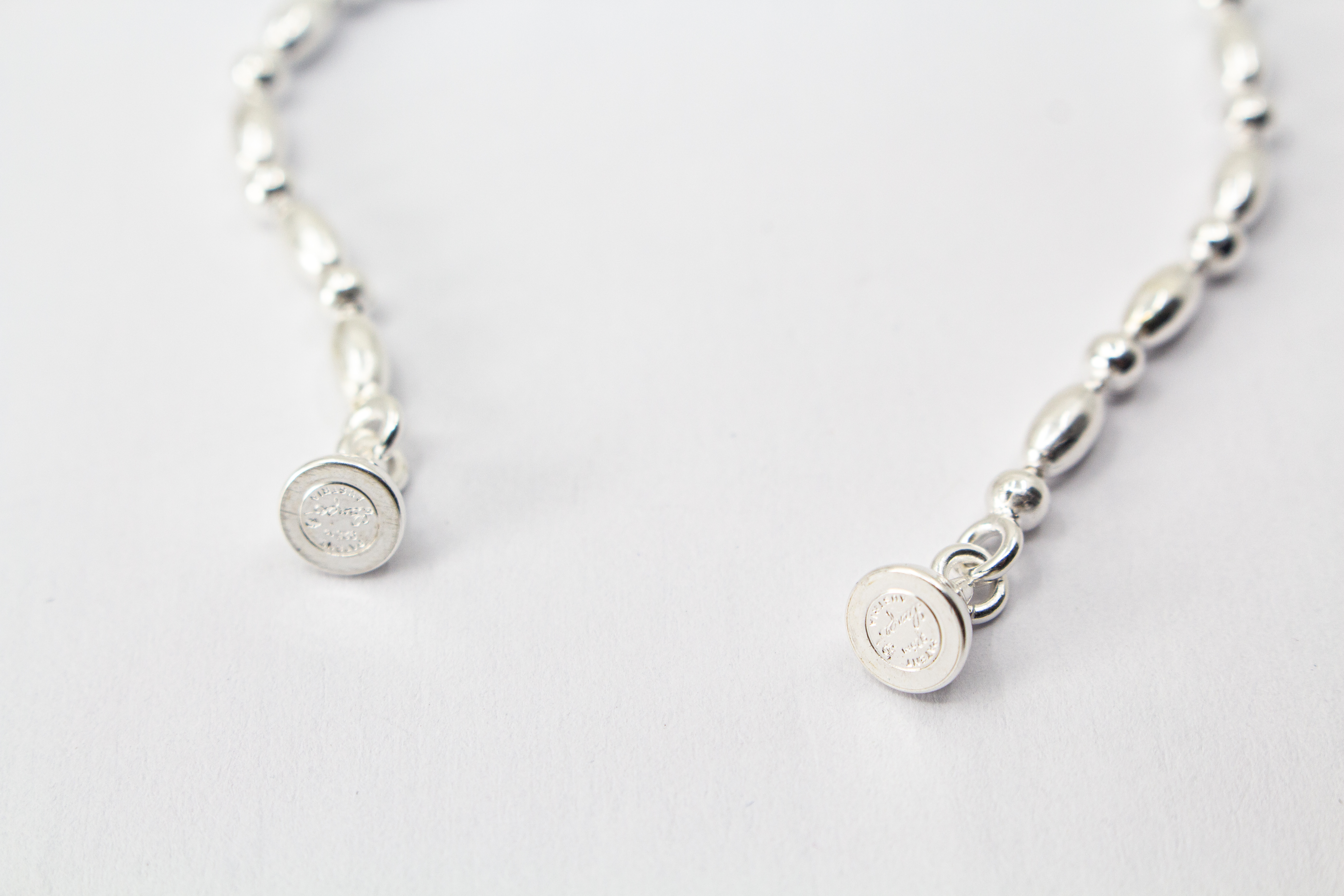 Filigrane Silberkette aus hochglanzpoliertem 925er Sterlingsilber mit einem rhythmischen Wechsel aus Oliven- und Kugel-Elementen auf hellem Untergrund, exklusiv erhältlich im Schmuck-Onlineshop der Goldschmiede Regina Kraus.