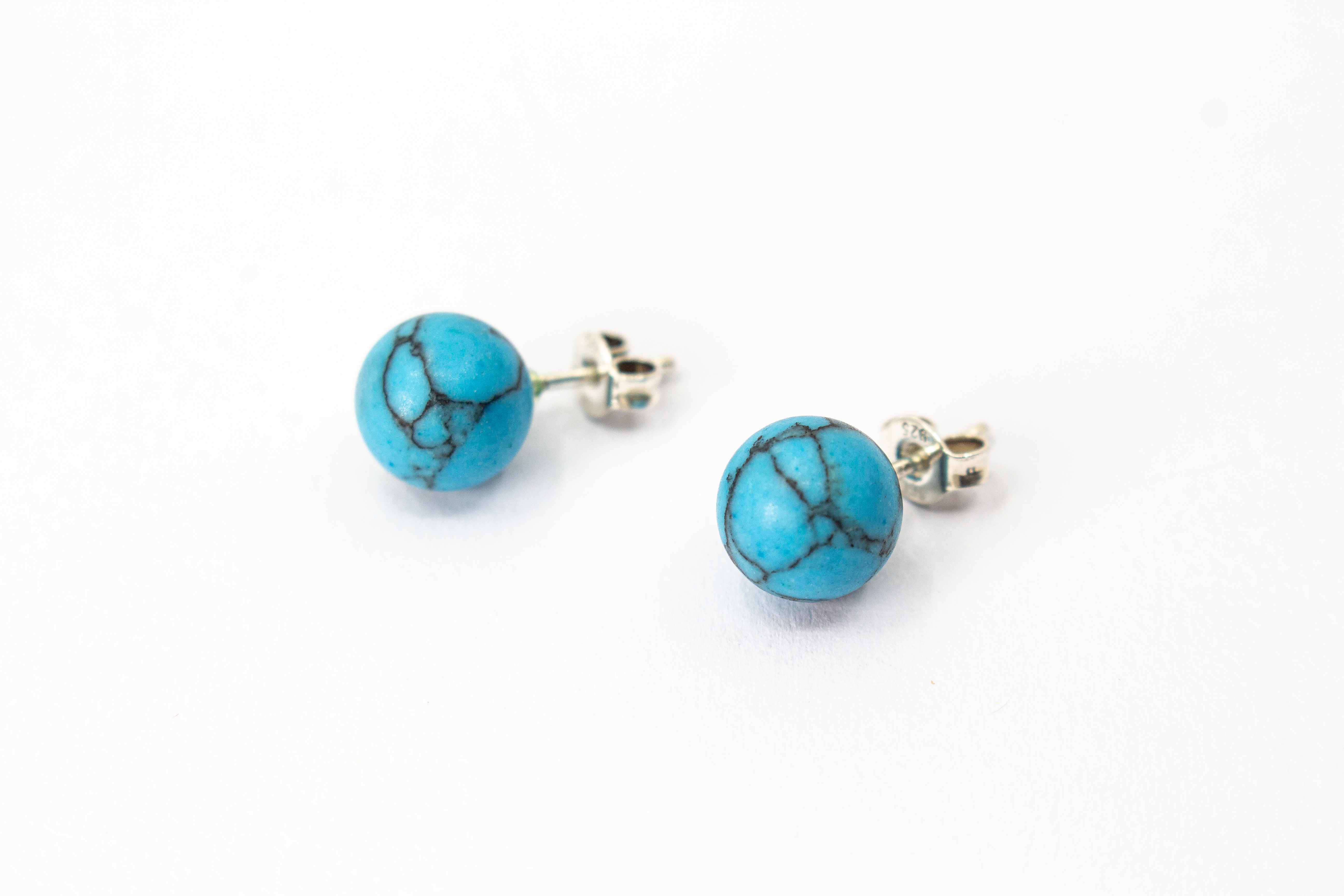 Klassische Kugelohrstecker aus leuchtend blauem Türkis-Edelstein mit charakteristischer dunkler Aderung und Stiften aus 925 Sterling Silber aus dem Online-Shop der Goldschmiede Regina Kraus.