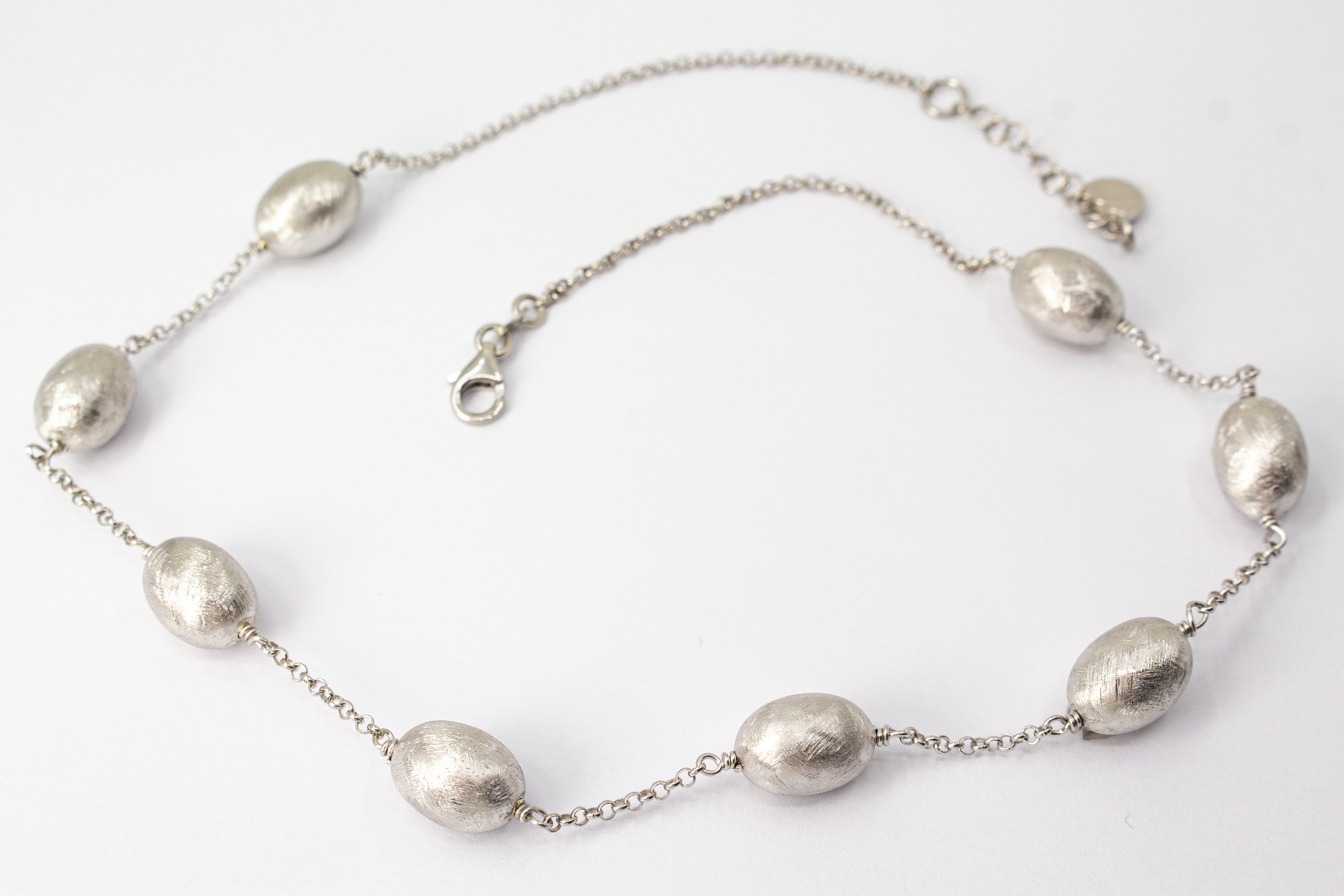 Eismattes Collier aus rhodiniertem 925er Sterlingsilber von Diva Gioielli mit ovalen, strukturierten Schmuckelementen an einer feinen Silberkette