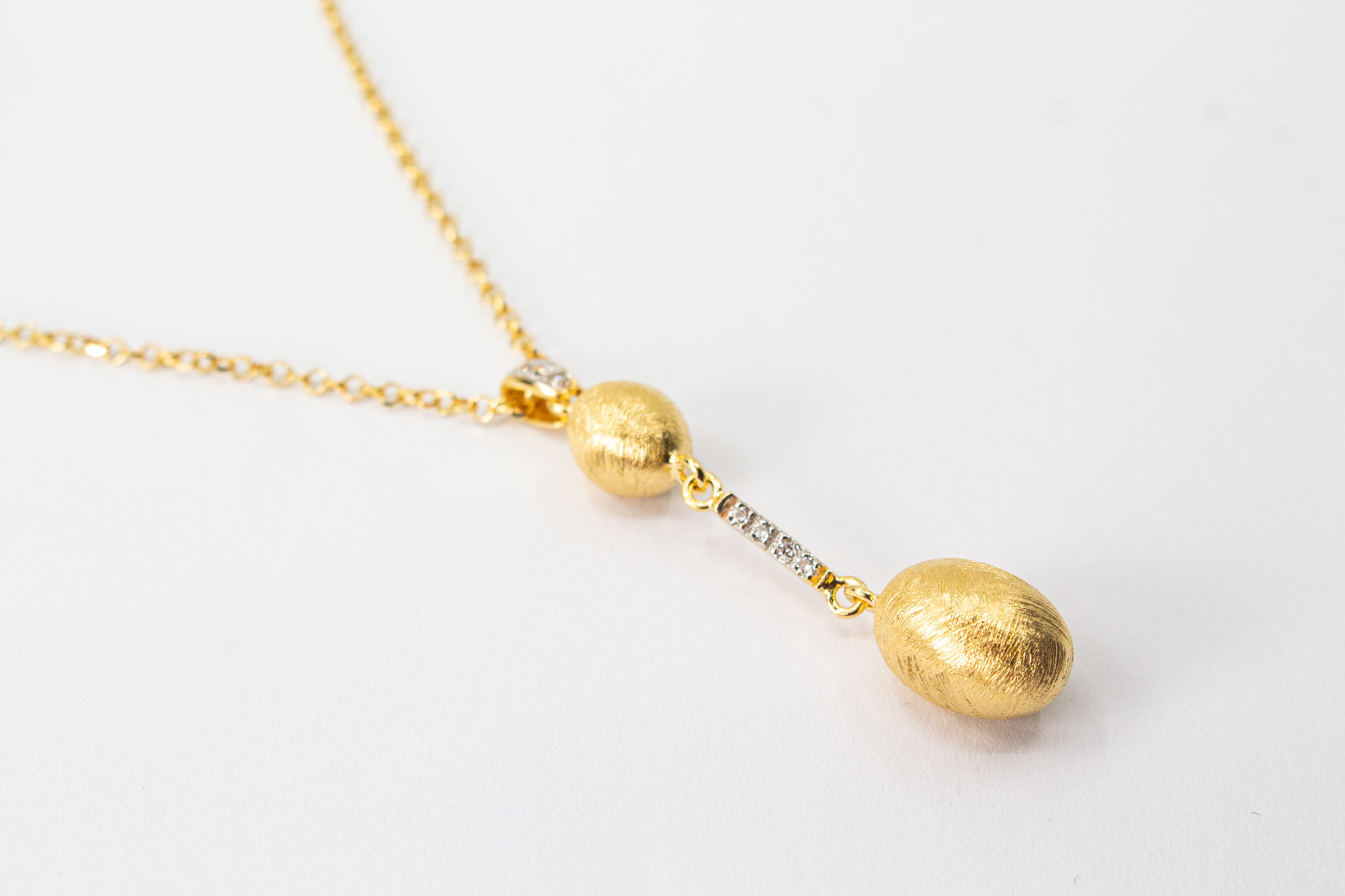Elegante Halskette von Diva Gioielli aus vergoldetem 925 Silber mit zwei mattierten, ovalen Schmuckelementen, die durch einen mit funkelnden Zirkonia besetzten Steg verbunden sind.