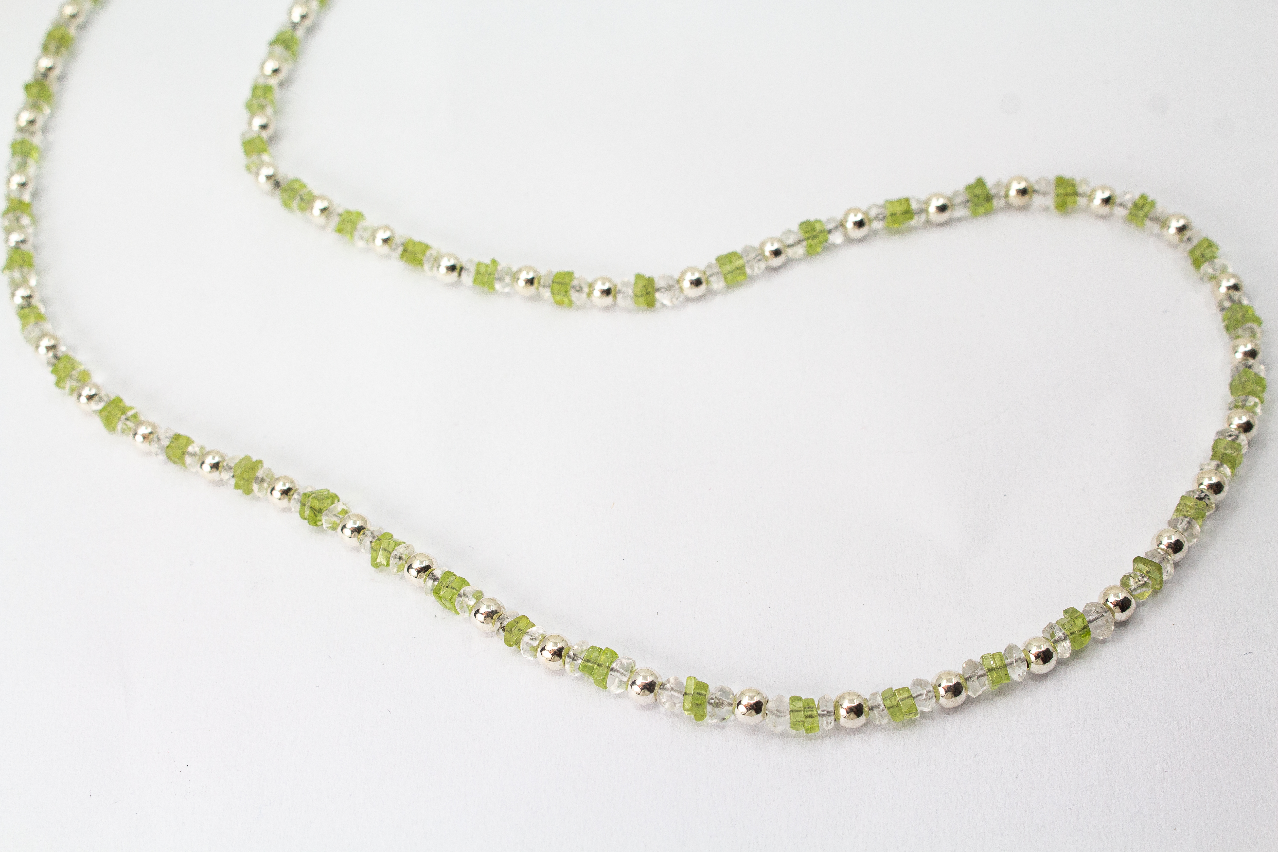 Filigrane Edelsteinhalskette aus hellgrünen Peridot-Splittern, klaren Bergkristall-Elementen und glänzenden 925 Sterling Silberkugeln aus dem Online-Shop der Goldschmiede Regina Kraus