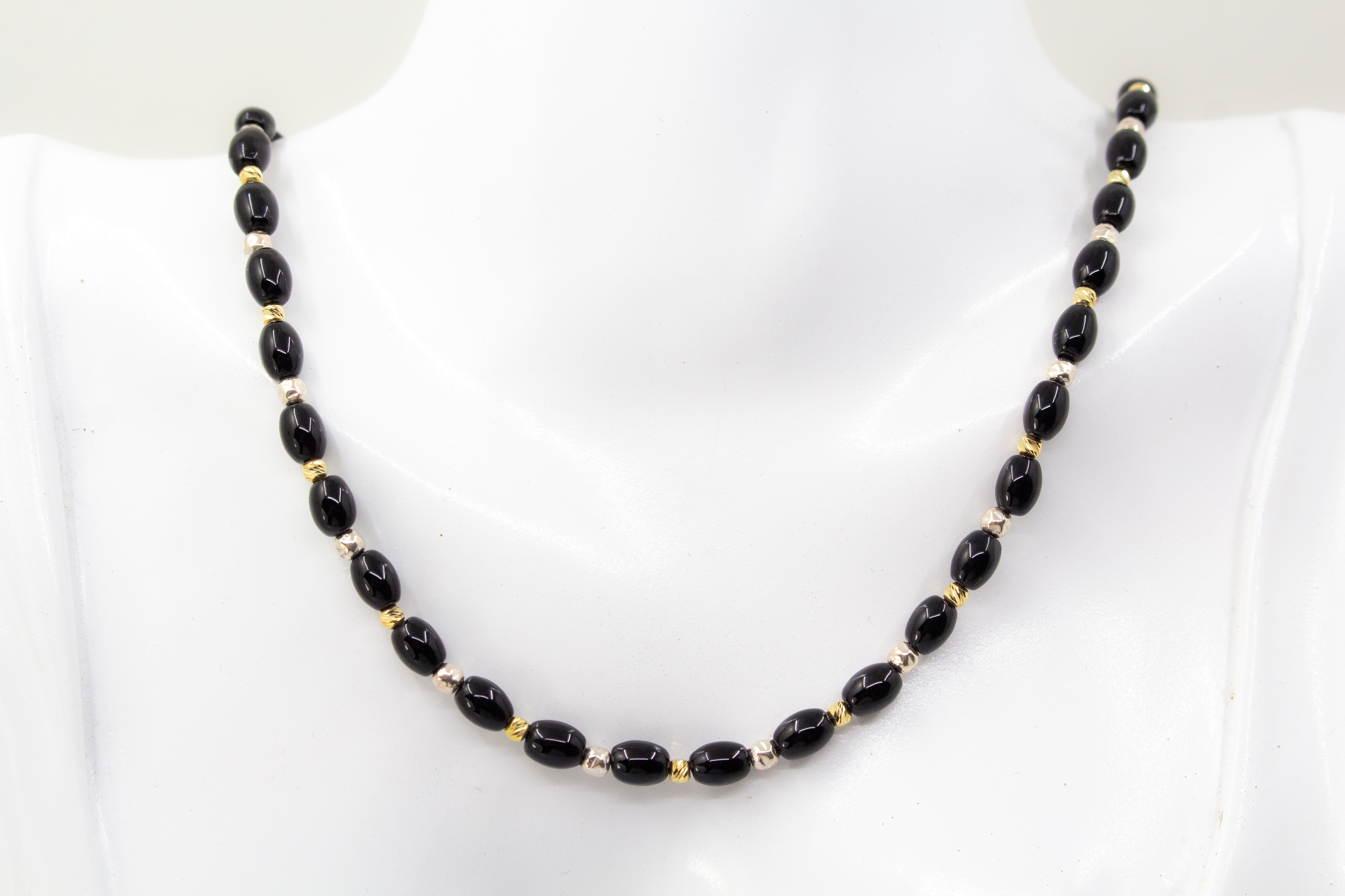 Elegante Onyx Kette „Mitternachtsglanz“ mit schwarzen Onyx-Perlen, Zwischenteilen aus 925er Sterlingsilber und vergoldeten Silberdetails.