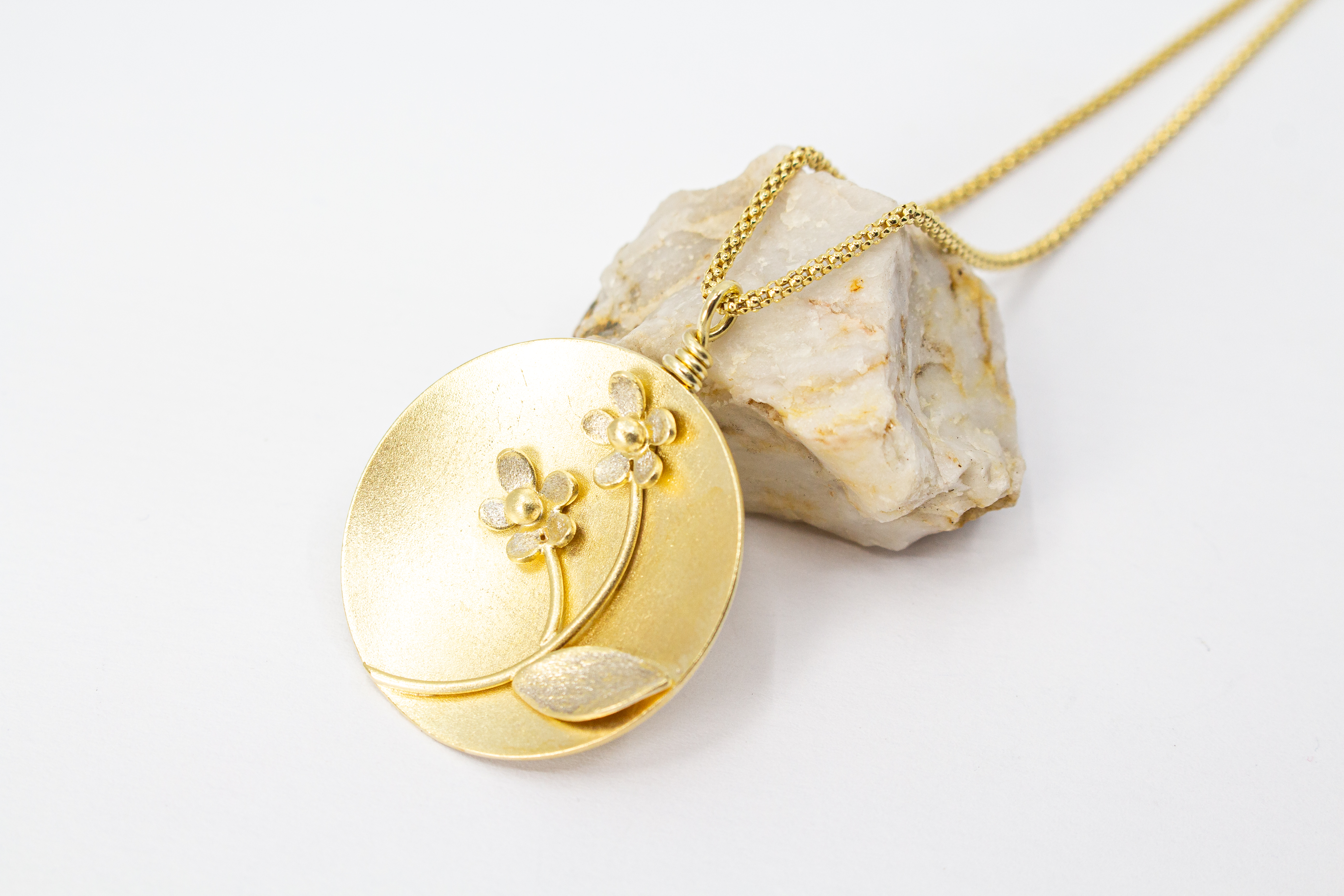 Feine Halskette mit rundem, matt vergoldetem Medaillon-Anhänger aus 20 Mikron plattiertem 925er Sterlingsilber, verziert mit einem plastischen Blumen-Motiv mit zwei Blüten und einem Blatt