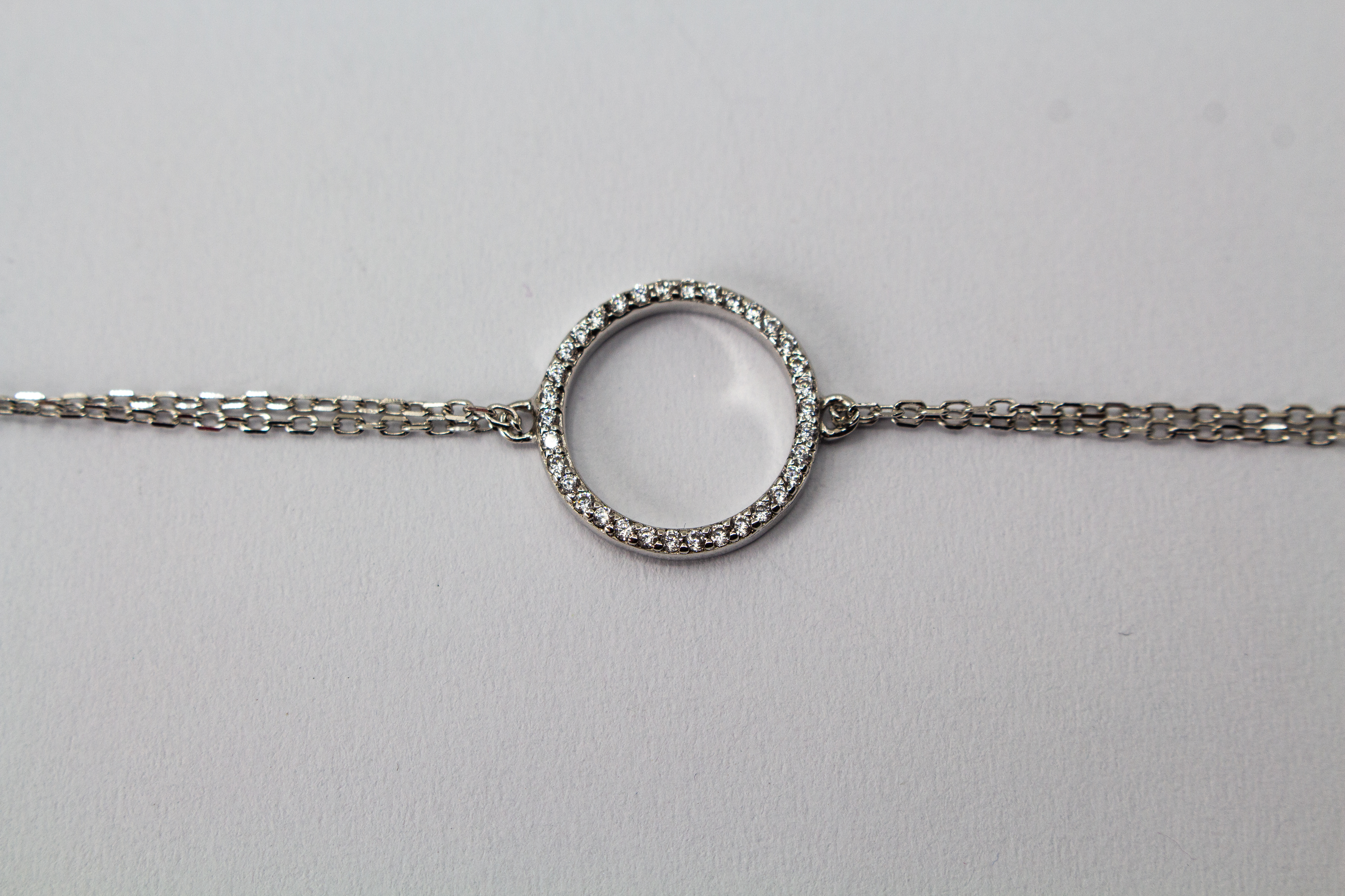 Zartes, rhodiniertes 925er Silberarmband mit einem integrierten, rundum mit Zirkonia besetzten Kreis-Element im Onlineshop von Goldschmiede Regina Kraus.